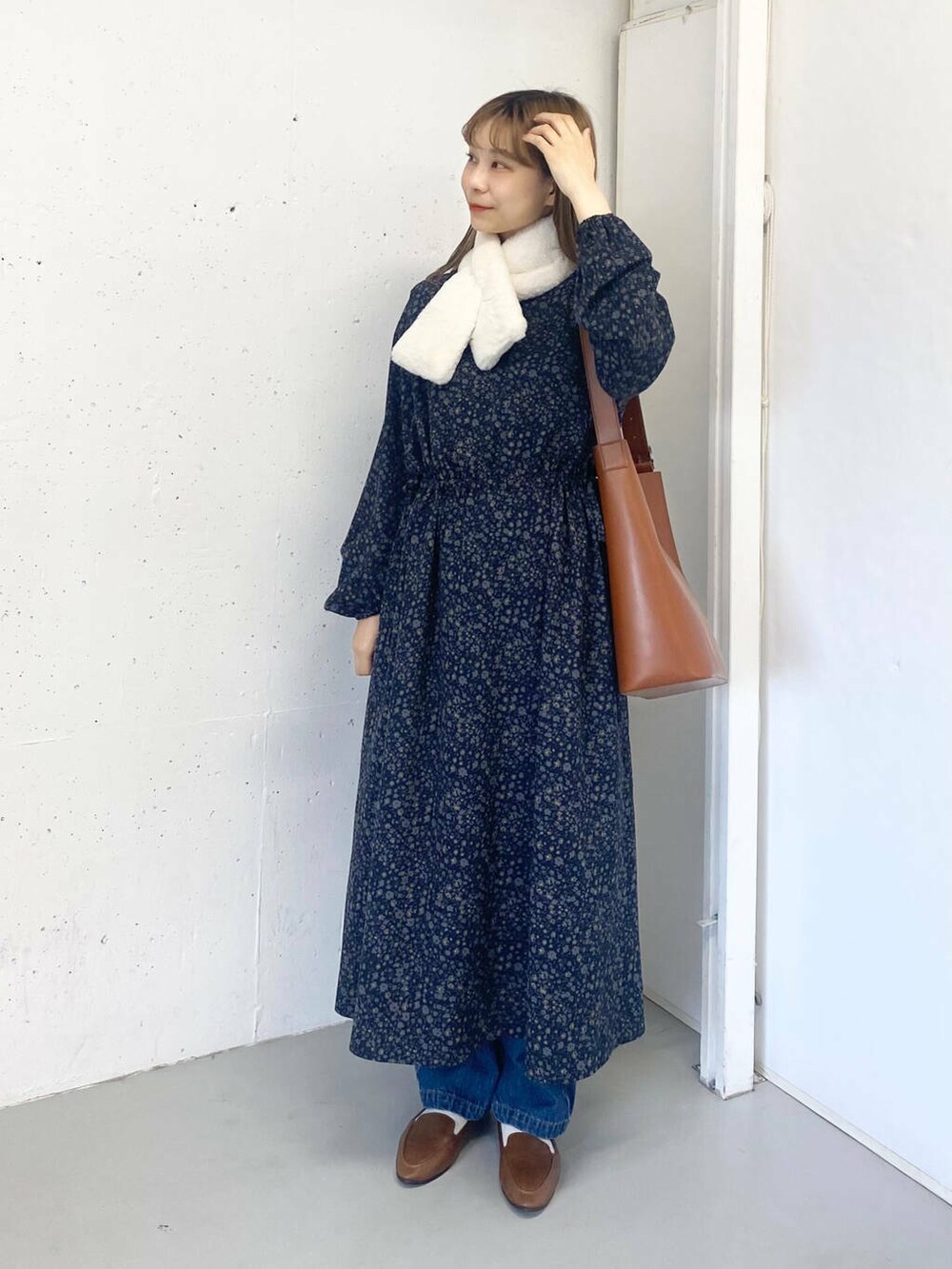 ブラウン系のスリッポン、ブルー系のデニムパンツ、ブラウン系のトートバッグを着用したレディースの秋コーディネートの7枚目の写真