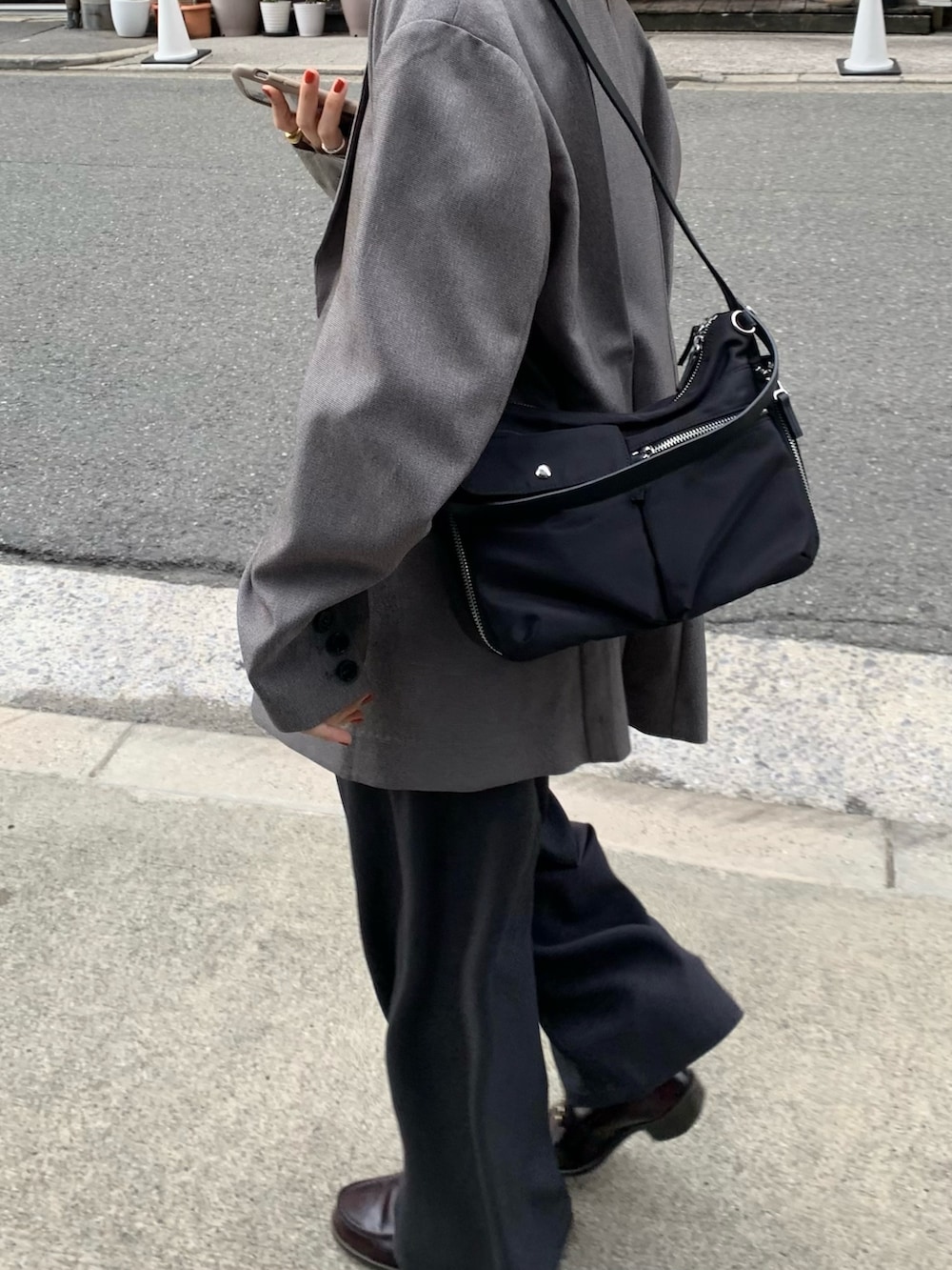 ブラック系のショルダーバッグ、グレー系のその他アウター、ブルー系のシャツ/ブラウスを着用したレディースの秋コーディネートの4枚目の写真