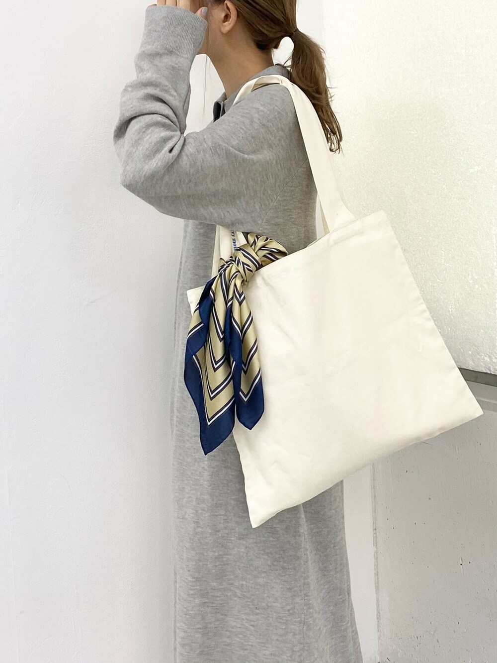 ブラック系のブーツ、グレー系のワンピース、ホワイト系のトートバッグを着用したレディースの秋コーディネートの5枚目の写真