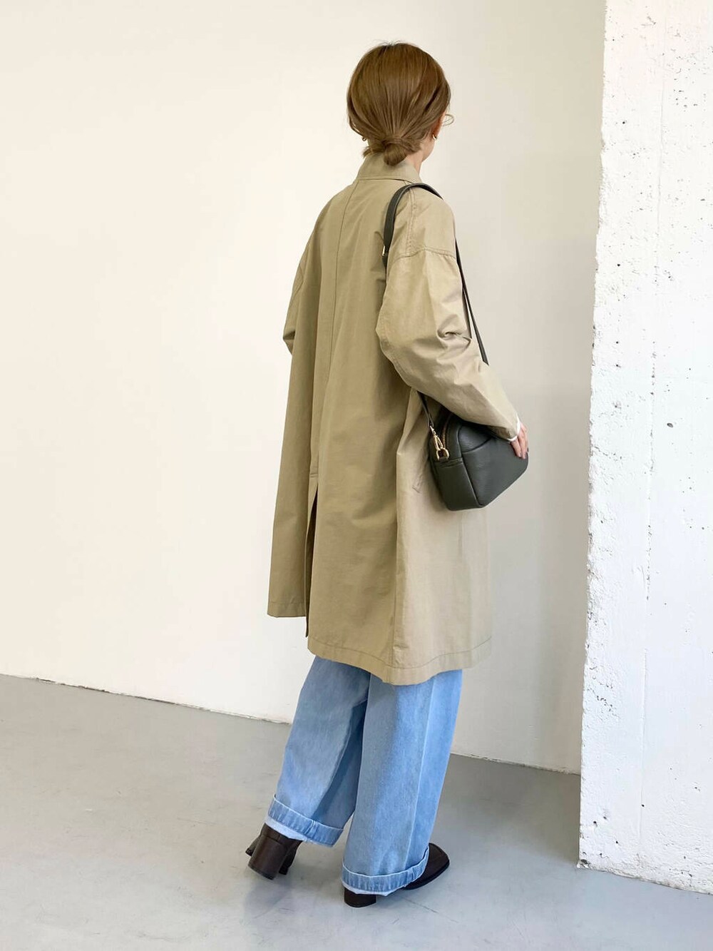 グリーン系のショルダーバッグ、ブラック系のブーツ、その他のニット/セーターを着用したレディースの冬コーディネートの4枚目の写真