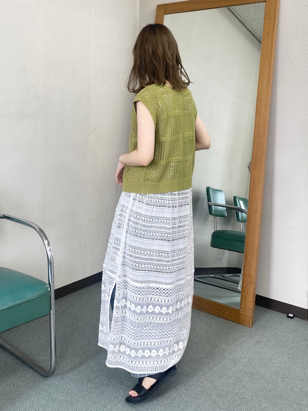グリーン系のニット/セーター、ホワイト系のワンピース、ホワイト系のネックレスを着用したレディースの夏コーディネートの3枚目の写真
