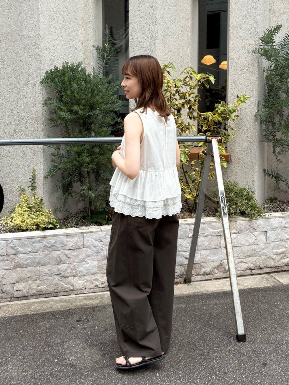 ホワイト系のシャツ/ブラウス、グレー系のその他パンツ、シルバー系のネックレスを着用したレディースの夏コーディネートの2枚目の写真