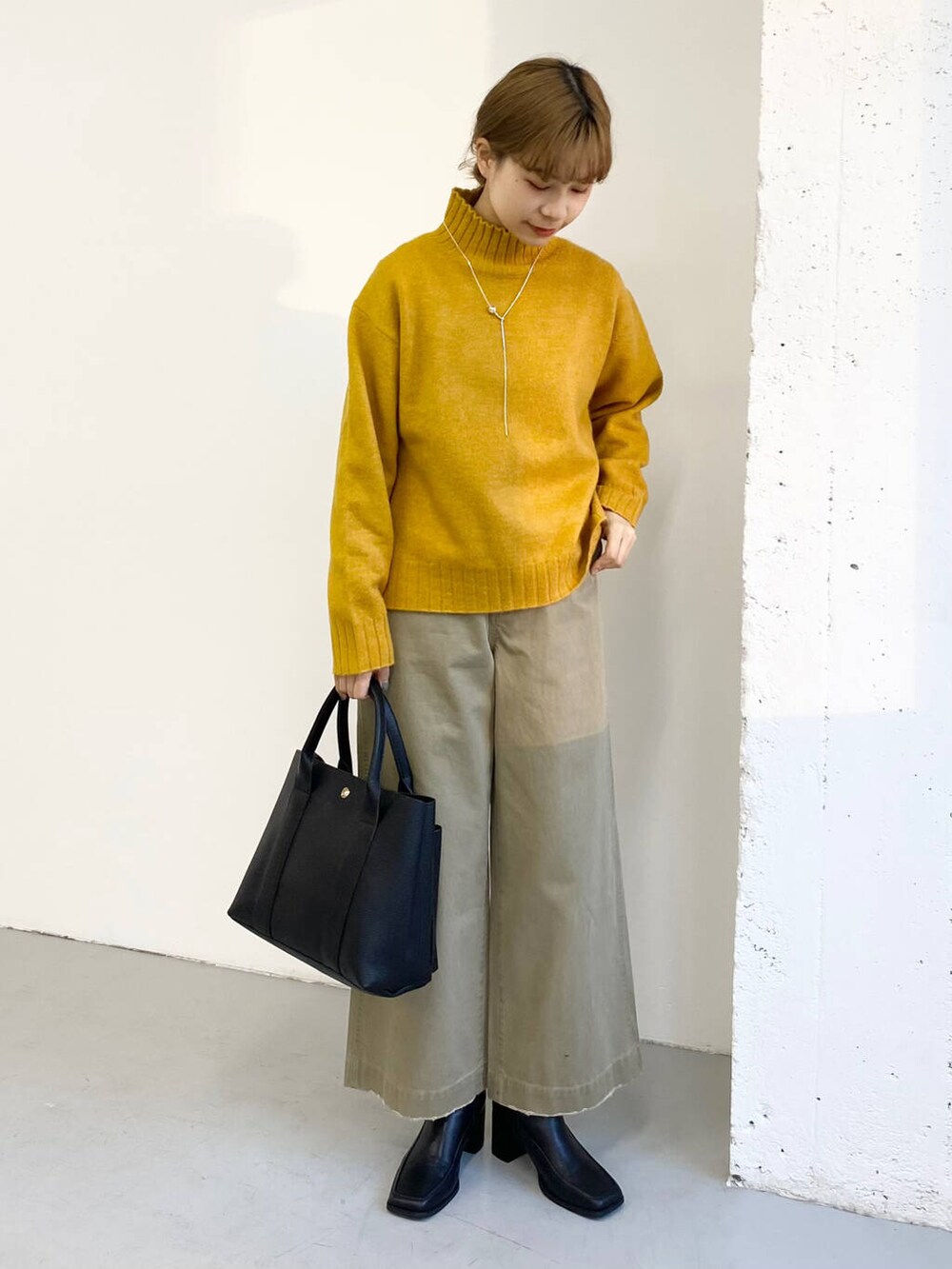 ブラック系のブーツ、ベージュ系のその他パンツ、ブラック系のトートバッグを着用したレディースの冬コーディネートの2枚目の写真