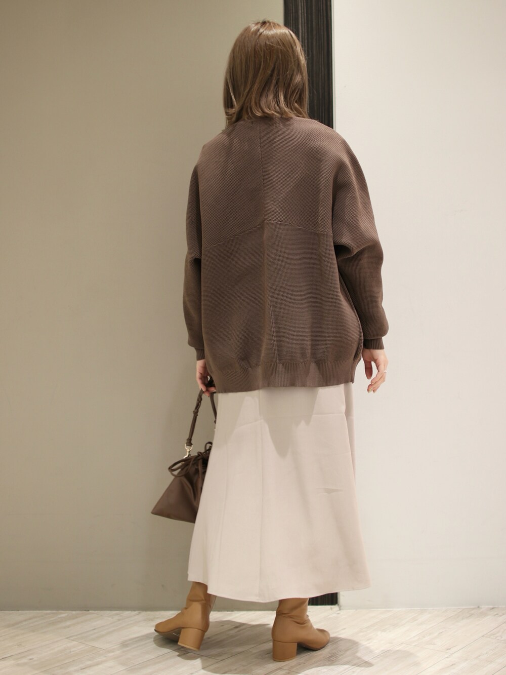 ブラウン系のカーディガン/ボレロ、ブラック系のTシャツ/カットソー、グレー系のスカートを着用したレディースの冬コーディネートの4枚目の写真