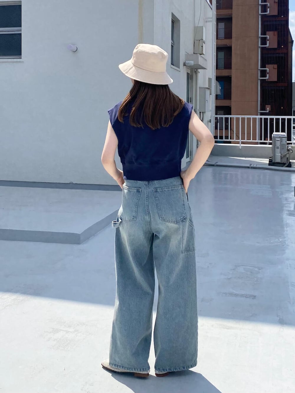 ブルー系のデニムパンツ、ホワイト系のバレエシューズ、ブルー系のスウェットを着用したレディースの春コーディネートの3枚目の写真