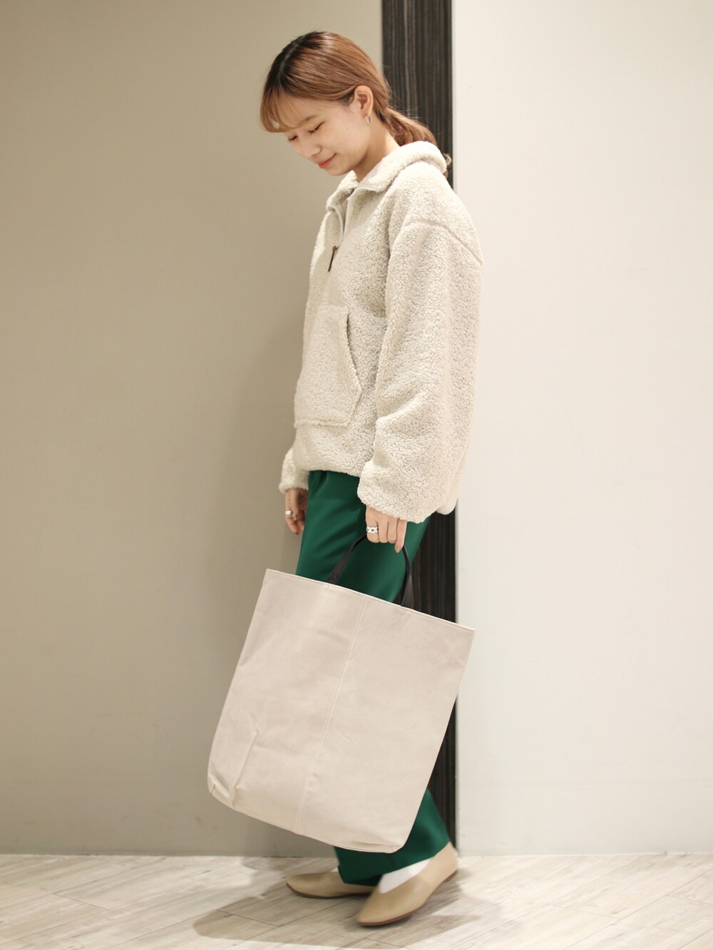 グリーン系のその他パンツ、ベージュ系のトートバッグ、ホワイト系のTシャツ/カットソーを着用したレディースの冬コーディネートの3枚目の写真