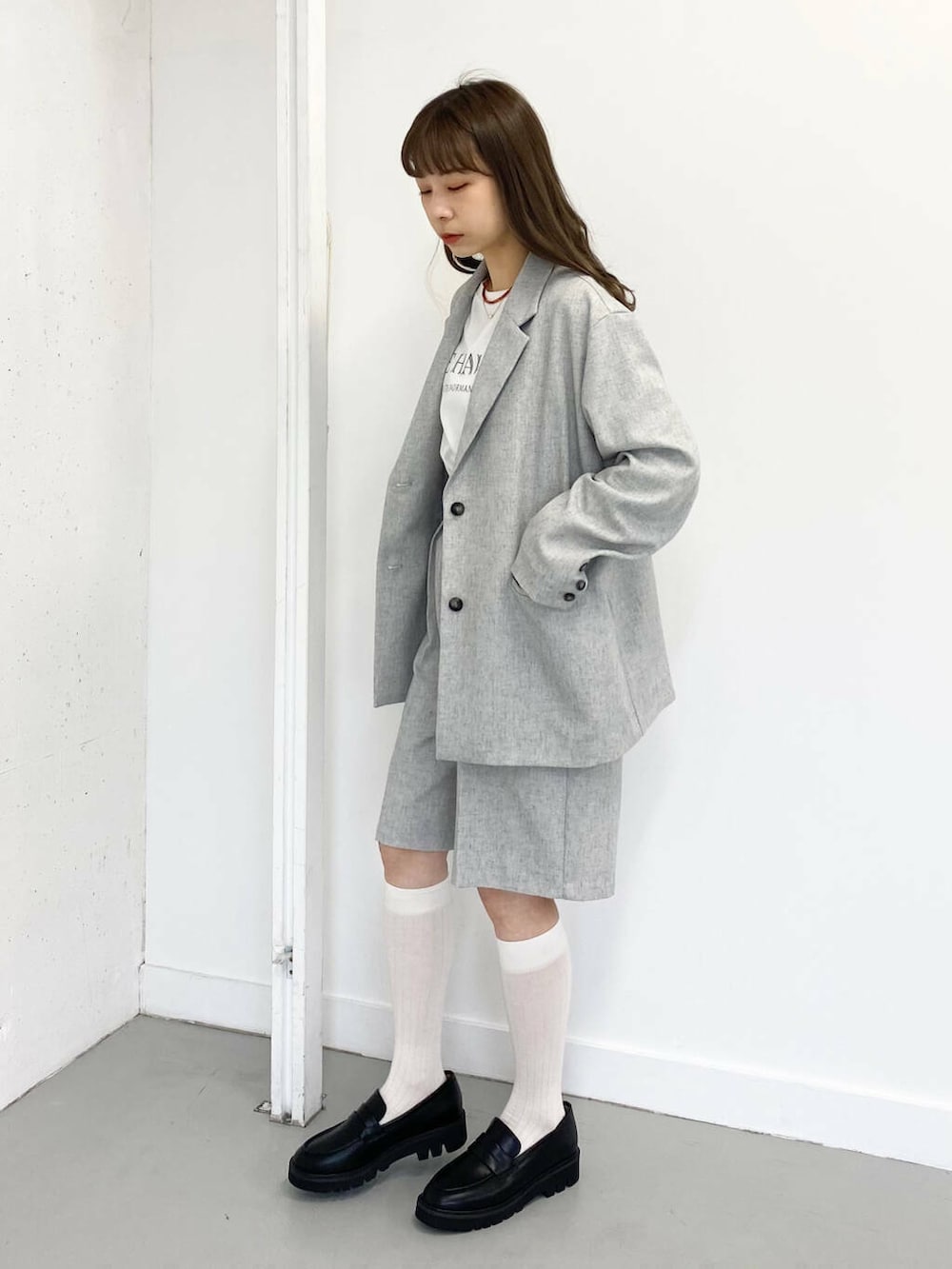 ブラック系のローファー、グレー系のその他パンツ、レッド系のネックレスを着用したレディースの春コーディネートの5枚目の写真
