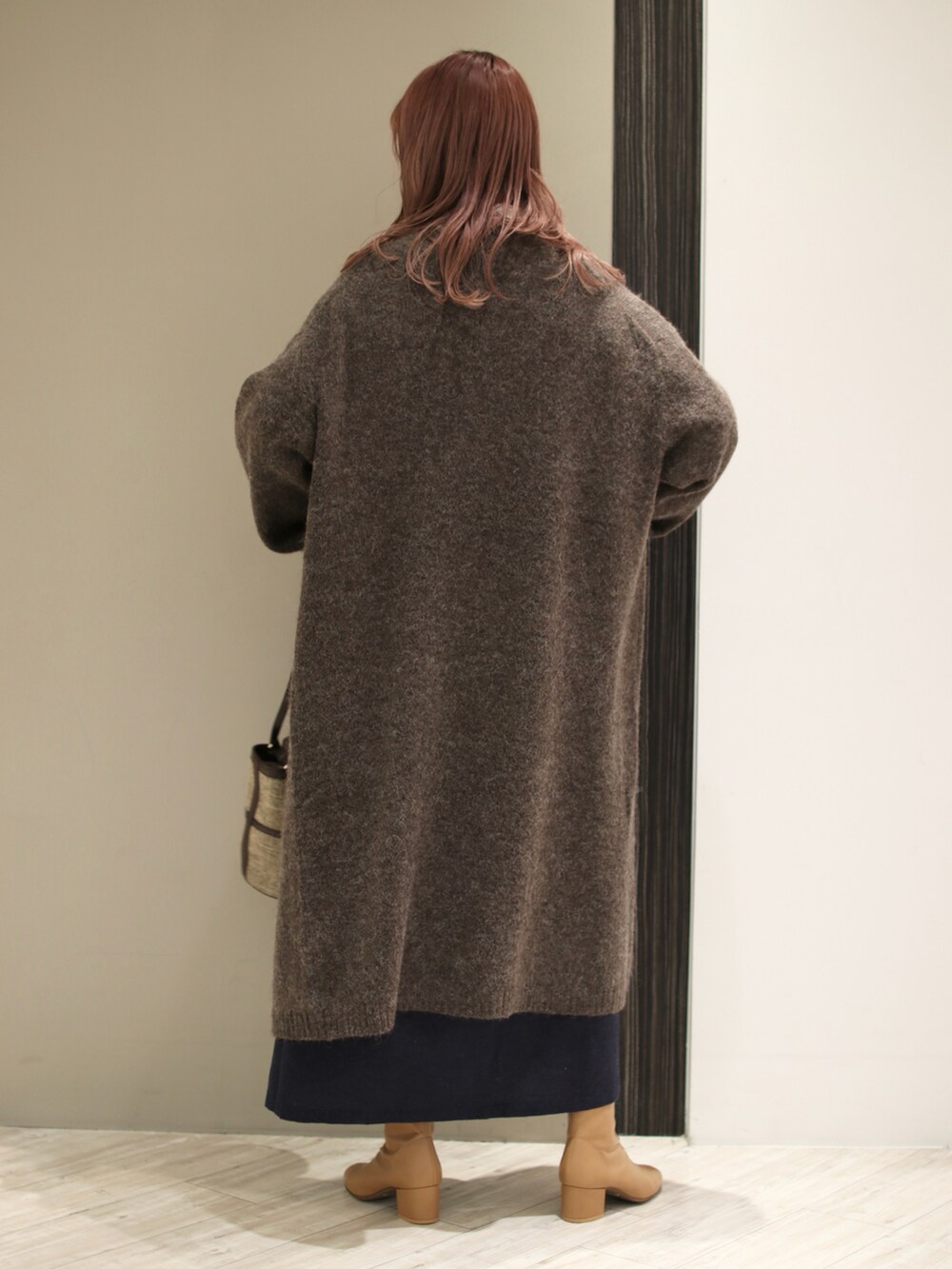 ブラウン系のショルダーバッグ、ブルー系のワンピース、ブラウン系のカーディガン/ボレロを着用したレディースの冬コーディネートの4枚目の写真