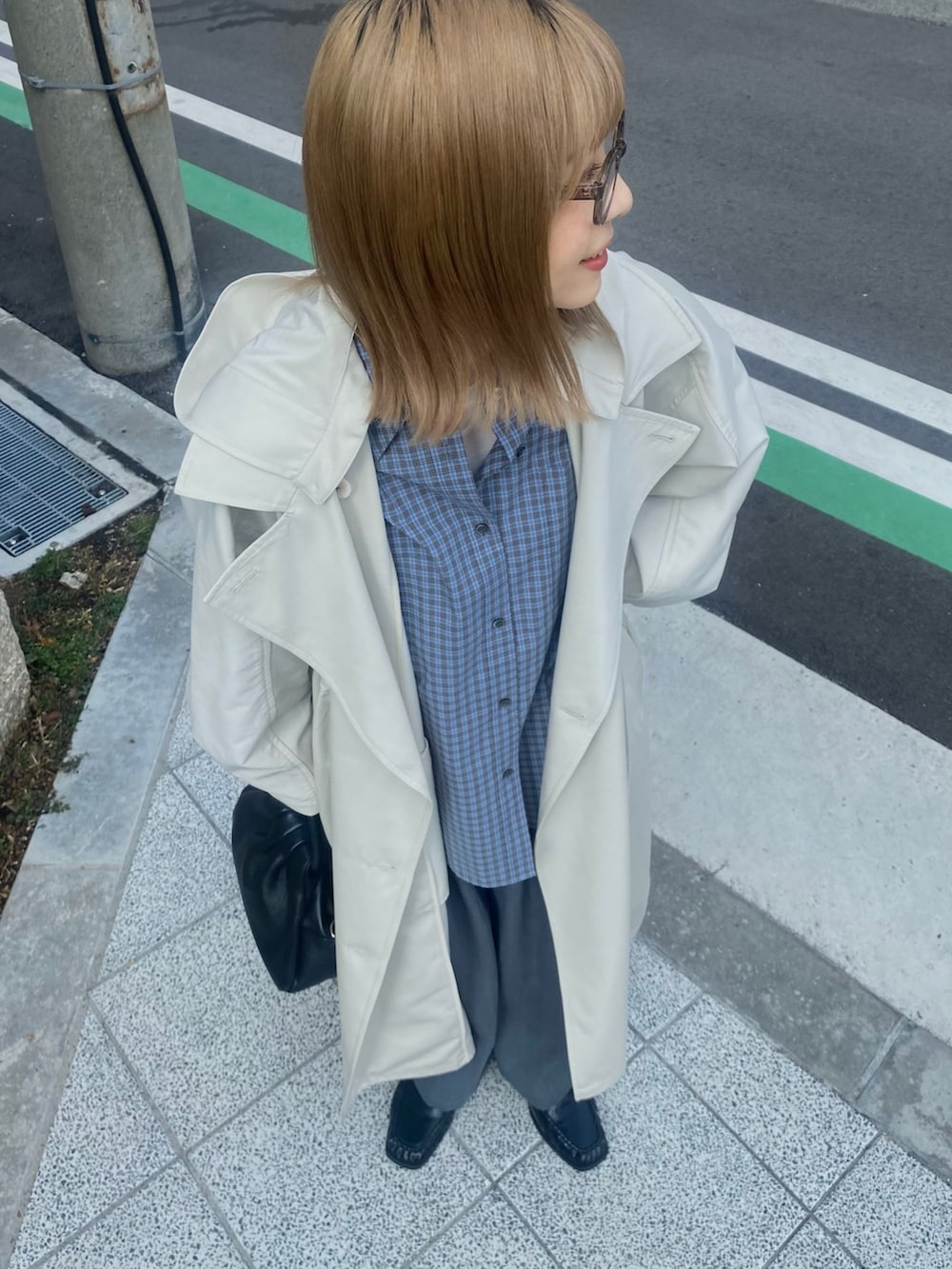 ブルー系のシャツ/ブラウス、ブラック系のローファー、ベージュ系のトレンチコートを着用したレディースの冬コーディネートの7枚目の写真