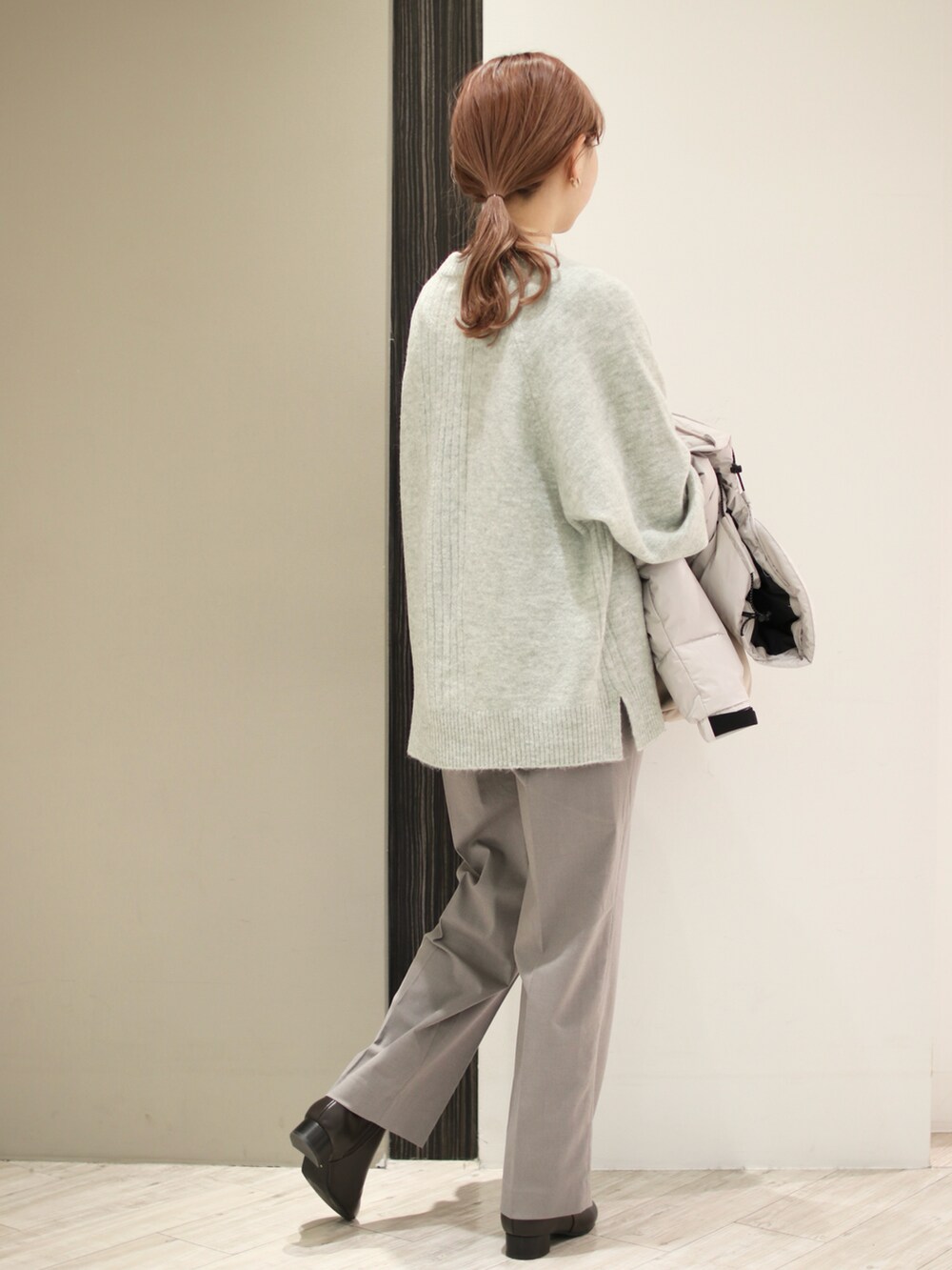グレー系のその他パンツ、ブラウン系のブーツ、グリーン系のニット/セーターを着用したレディースの冬コーディネートの4枚目の写真