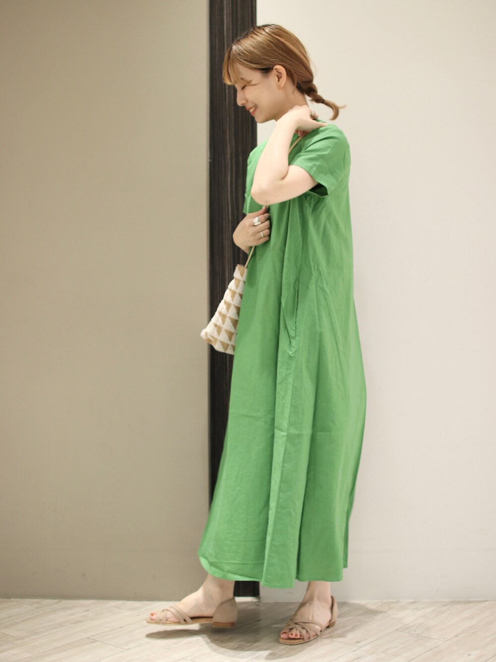 グリーン系のワンピース、ホワイト系のショルダーバッグ、ベージュ系のサンダルを着用したレディースの夏コーディネートの4枚目の写真