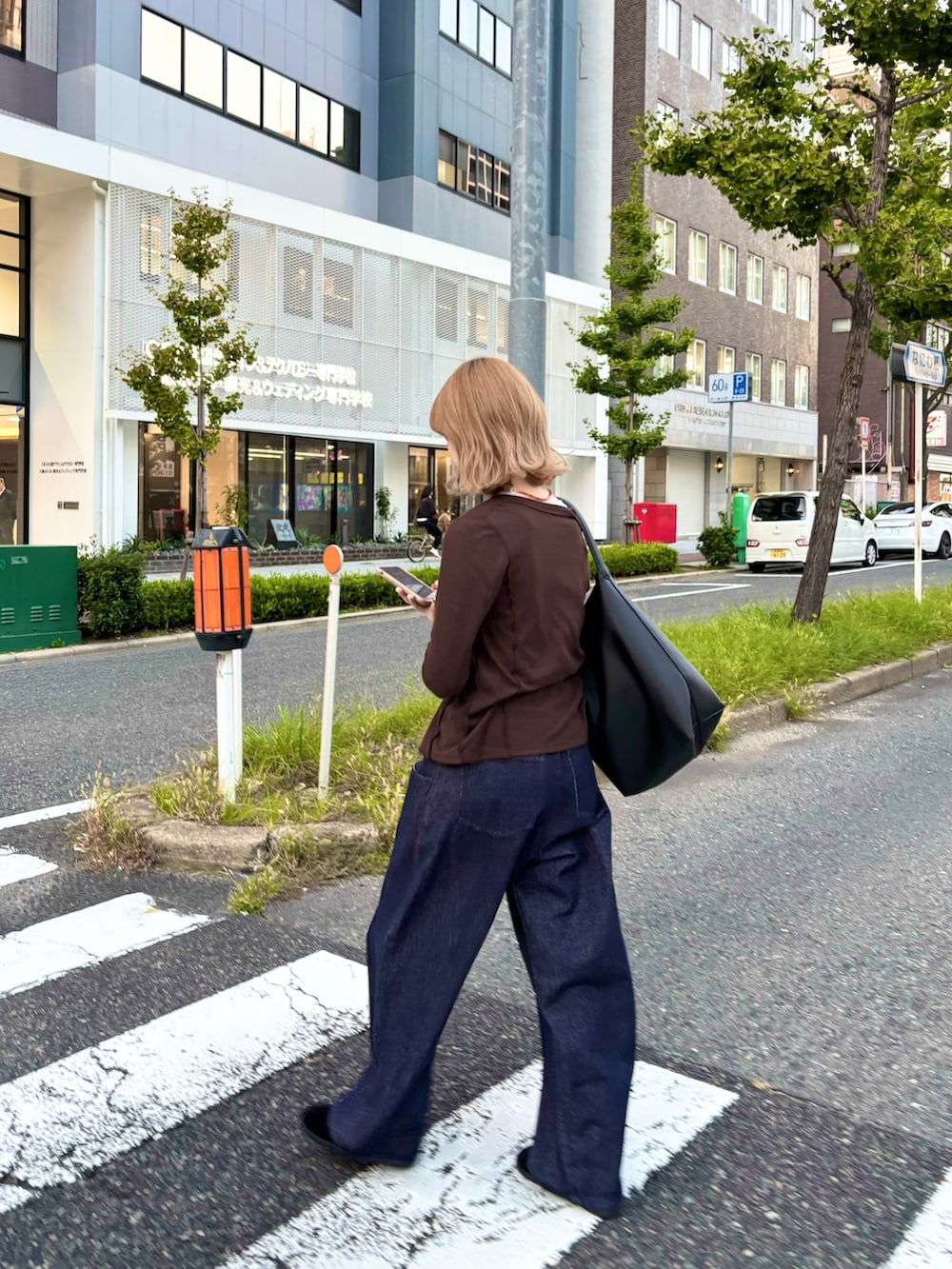 ブラック系のその他シューズ、ブラウン系のTシャツ/カットソー、ブラック系のトートバッグを着用したレディースの秋コーディネートの6枚目の写真
