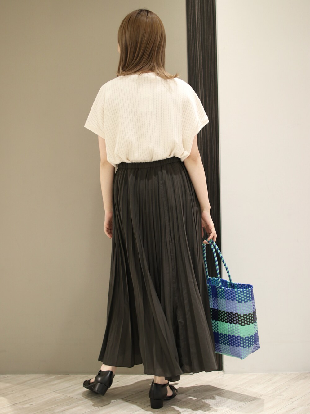 ブルー系のトートバッグ、ブラック系のサンダル、グレー系のスカートを着用したレディースの夏コーディネートの3枚目の写真