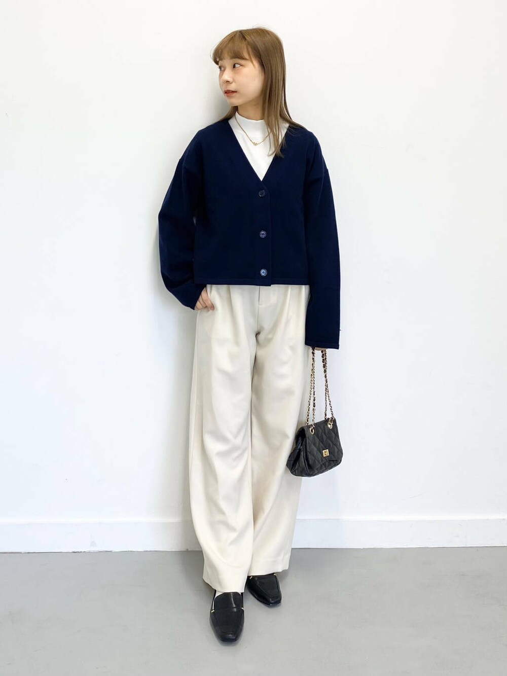 ブラック系のローファー、ブラック系のショルダーバッグ、ホワイト系のTシャツ/カットソーを着用したレディースの冬コーディネートの2枚目の写真