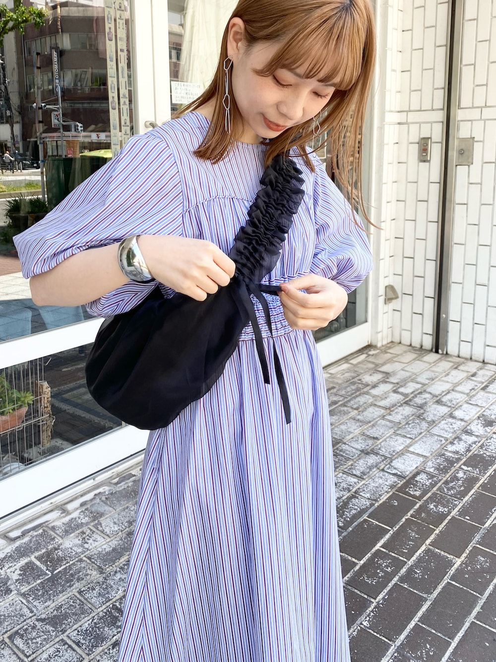 ブラック系のショルダーバッグ、パープル系のワンピース、シルバー系のサンダルを着用したレディースの夏コーディネートの5枚目の写真