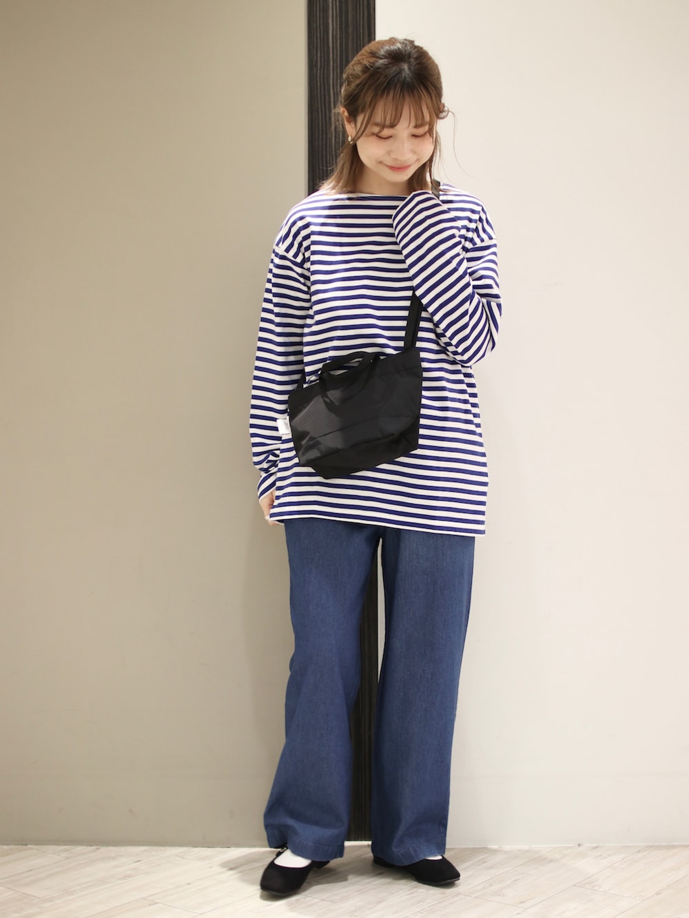 ブルー系のデニムパンツ、ブルー系のTシャツ/カットソー、ブラック系のバレエシューズを着用したレディースの冬コーディネートの4枚目の写真