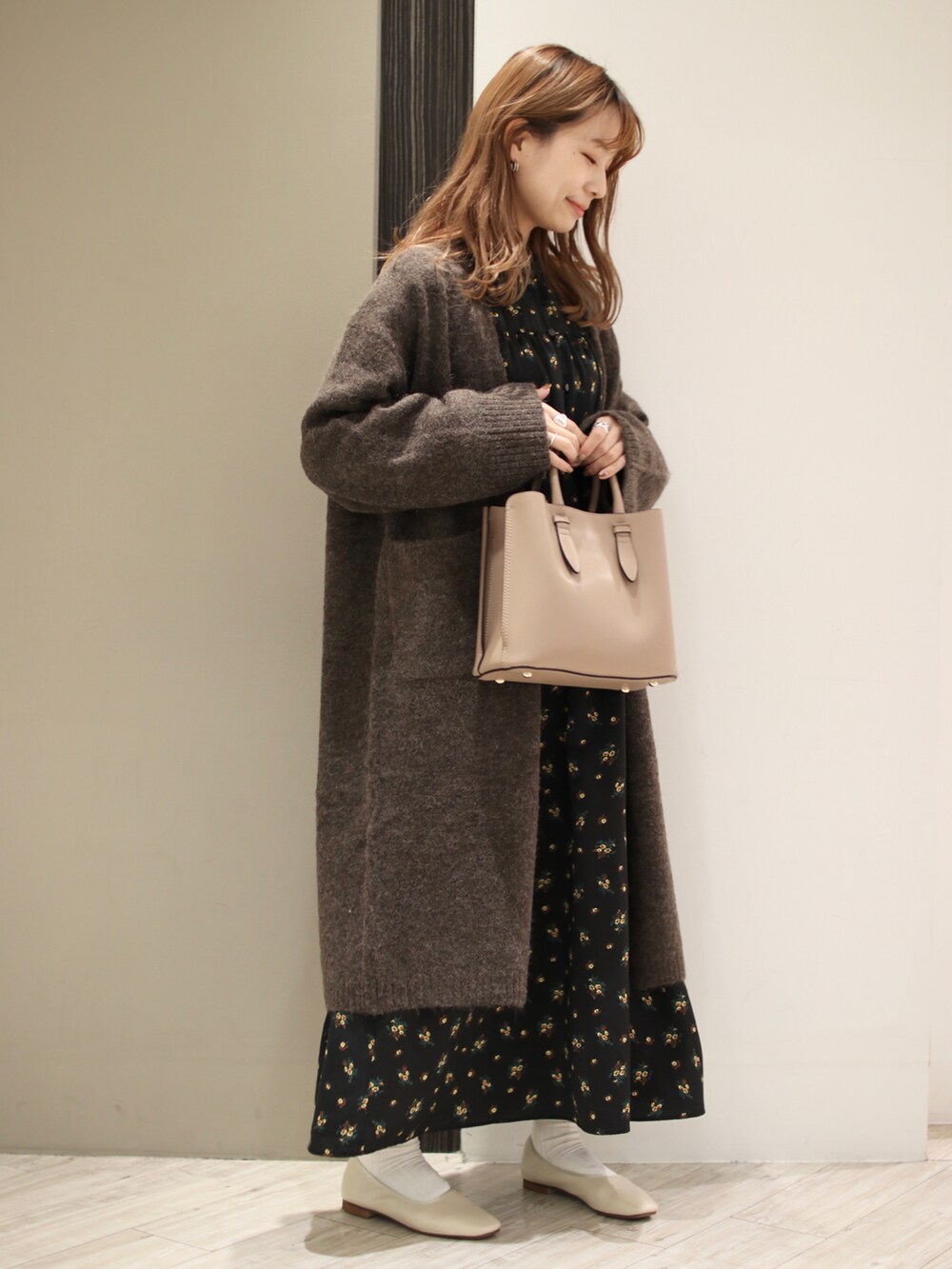 ブラウン系のトートバッグ、ブラック系のワンピース、ブラウン系のカーディガン/ボレロを着用したレディースの秋コーディネートの2枚目の写真