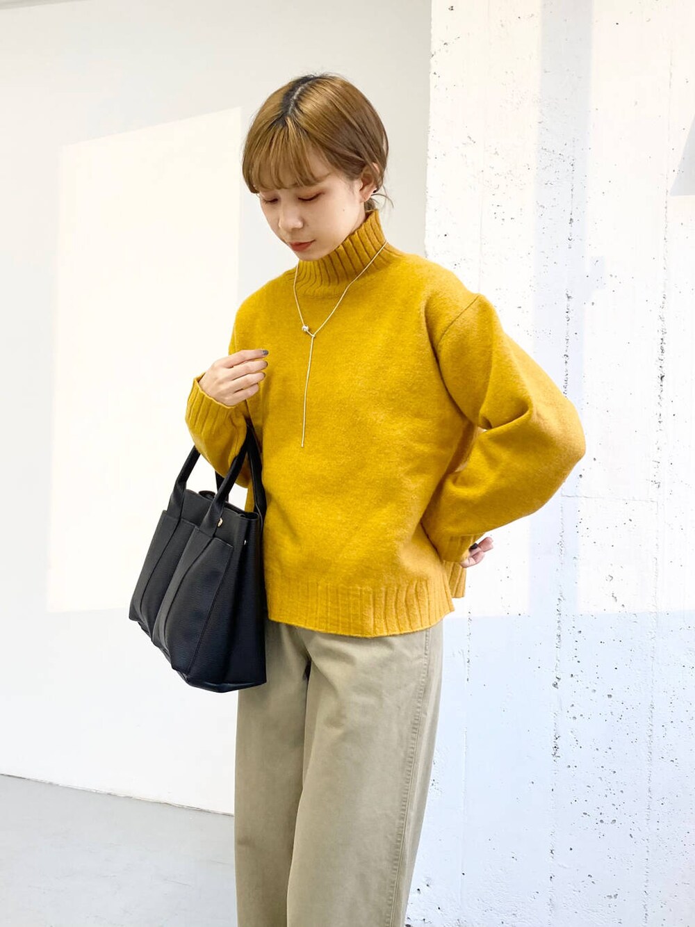 ブラック系のブーツ、ベージュ系のその他パンツ、ブラック系のトートバッグを着用したレディースの冬コーディネートの4枚目の写真