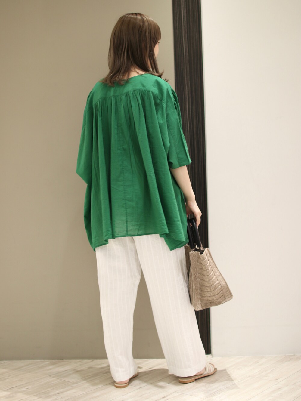 ベージュ系のトートバッグ、グリーン系のシャツ/ブラウス、ホワイト系のその他パンツを着用したレディースの夏コーディネートの3枚目の写真