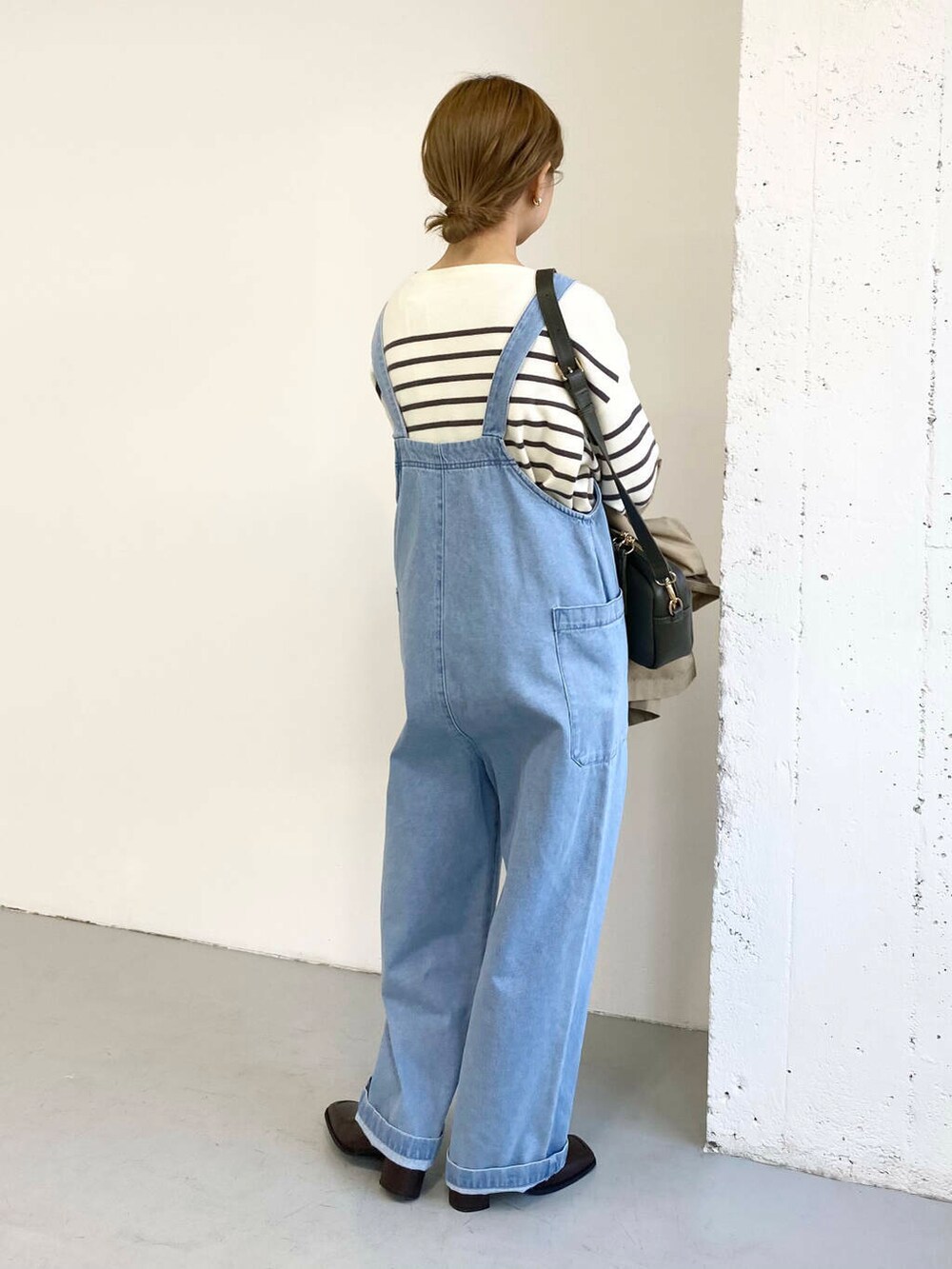 グリーン系のショルダーバッグ、ブラック系のブーツ、その他のニット/セーターを着用したレディースの冬コーディネートの7枚目の写真