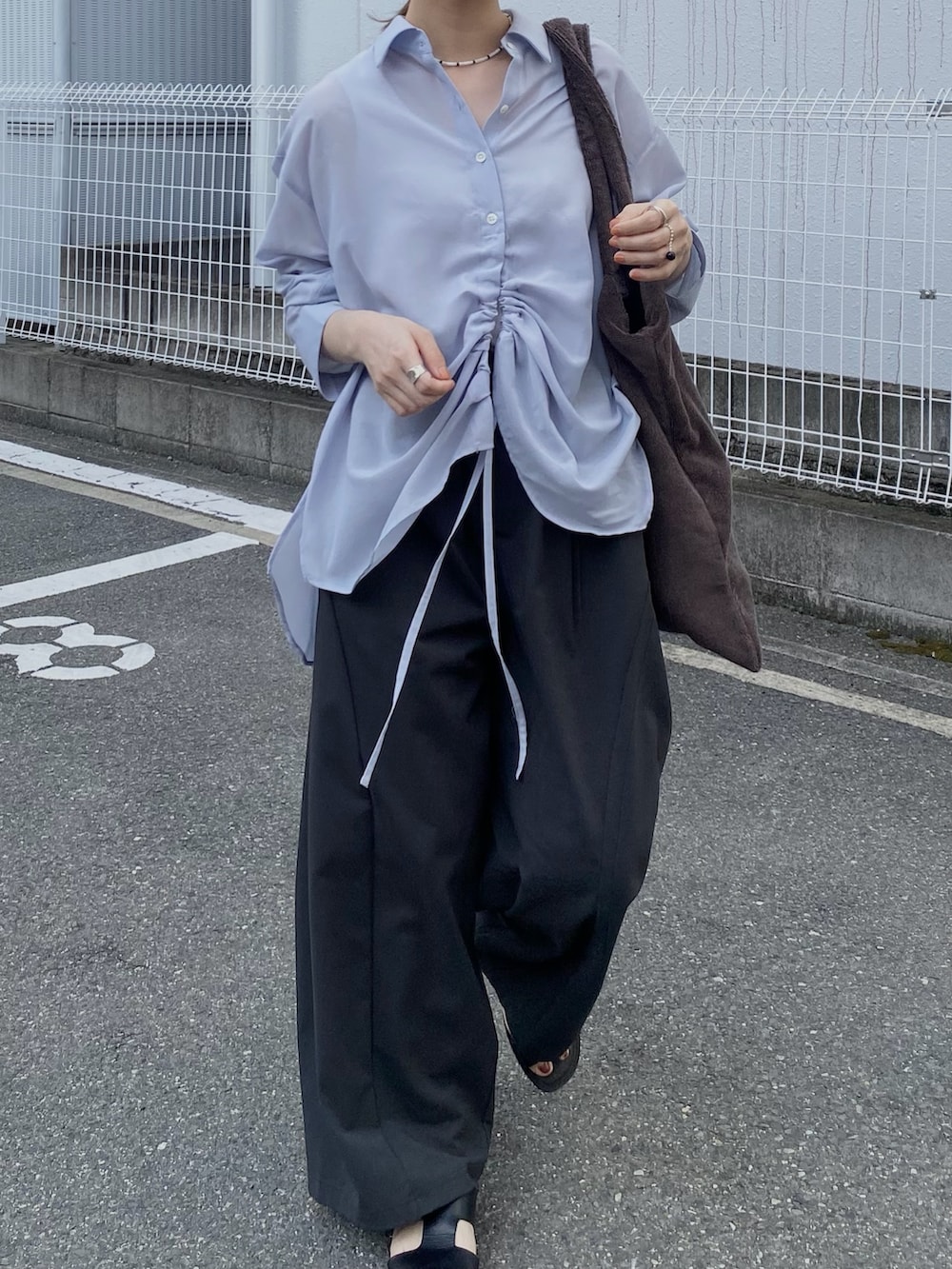 グレー系のその他パンツ、ブルー系のシャツ/ブラウス、ブラウン系のトートバッグを着用したレディースの夏コーディネートの2枚目の写真