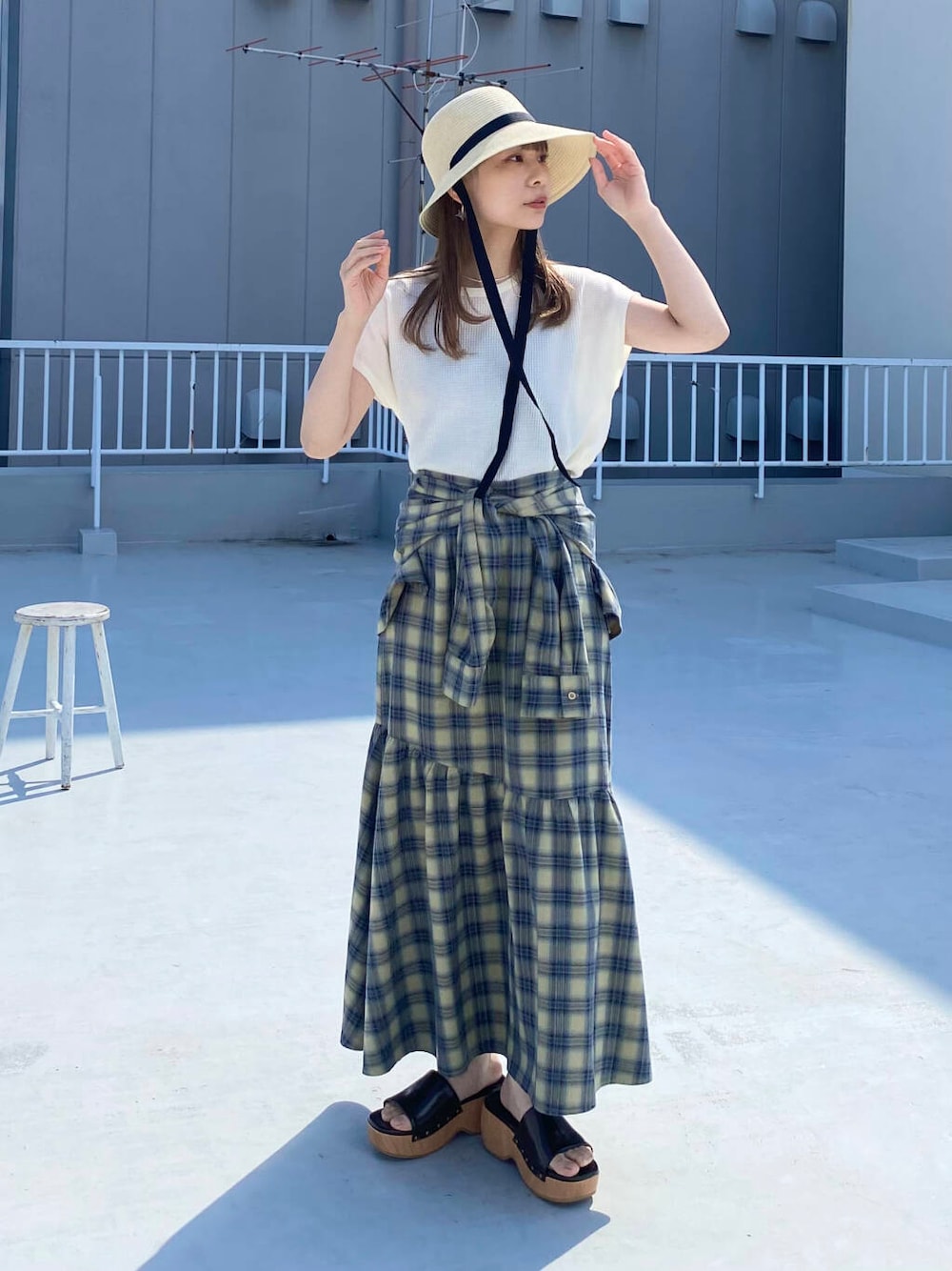 ベージュ系のスカート、ホワイト系のTシャツ/カットソー、ブラウン系のサンダルを着用したレディースの春コーディネートの6枚目の写真