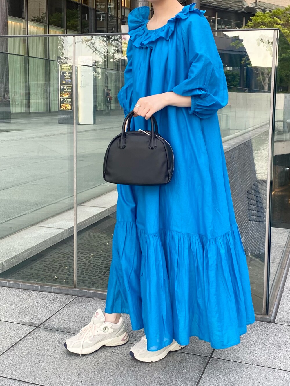 ブルー系のワンピース/ドレス、ブラック系のボストンバッグ、ホワイト系のスニーカーを着用したレディースの夏コーディネートの3枚目の写真
