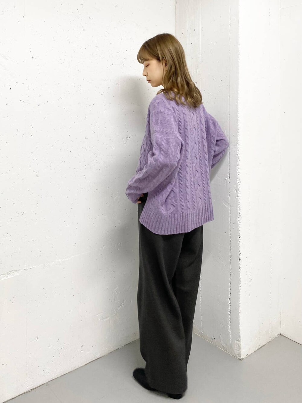 パープル系のニット/セーター、グレー系のその他パンツ、ブラック系のブーツを着用したレディースの秋コーディネートの4枚目の写真