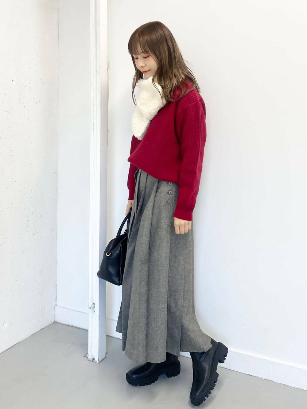 ブラック系のブーツ、ブラック系のボストンバッグ、グレー系のスカートを着用したレディースの冬コーディネートの3枚目の写真