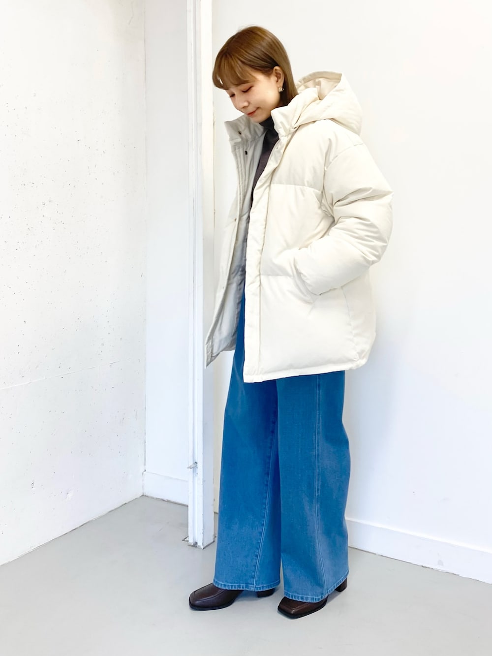 ブラウン系のブーツ、ブラウン系のニット/セーター、ホワイト系のダウンジャケット/コートを着用したレディースの冬コーディネートの4枚目の写真