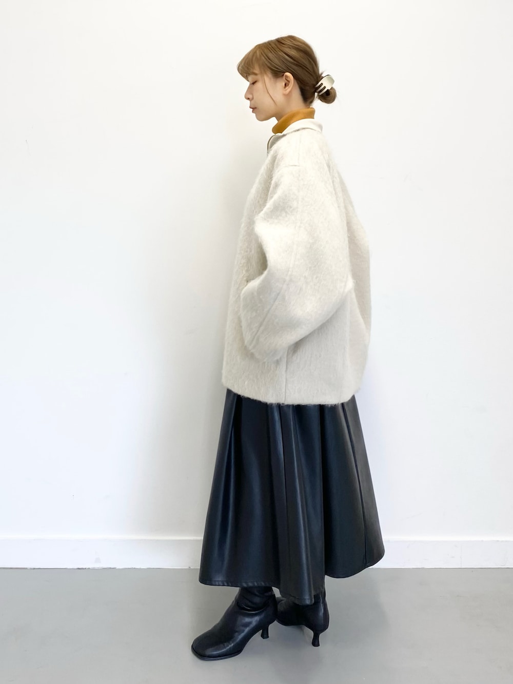 ブラック系のショルダーバッグ、ブラック系のブーツ、ブラック系のスカートを着用したレディースの冬コーディネートの3枚目の写真