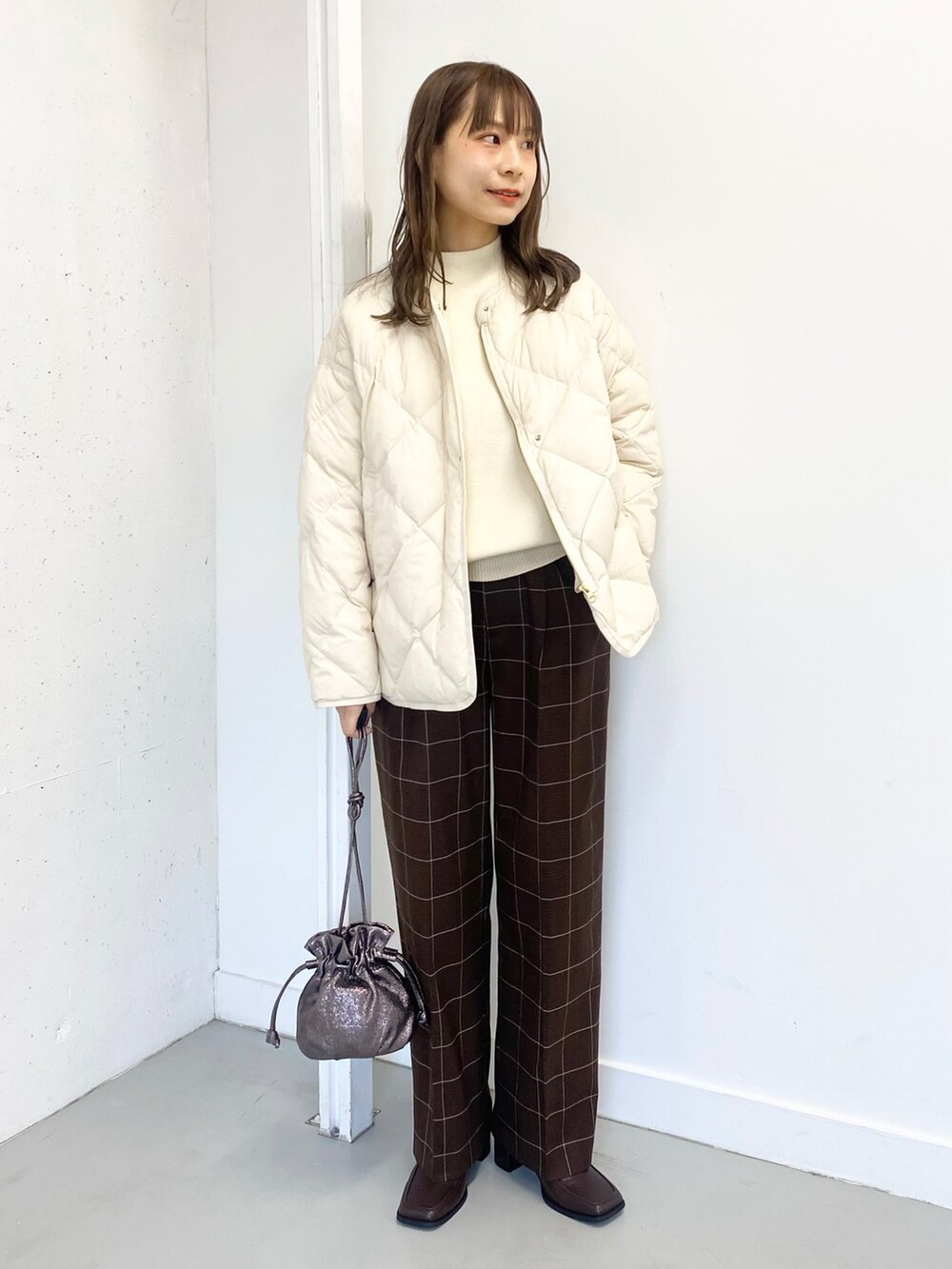 ブラウン系のブーツ、ブラウン系のその他パンツ、ホワイト系のダウンジャケット/コートを着用したレディースの冬コーディネートの3枚目の写真