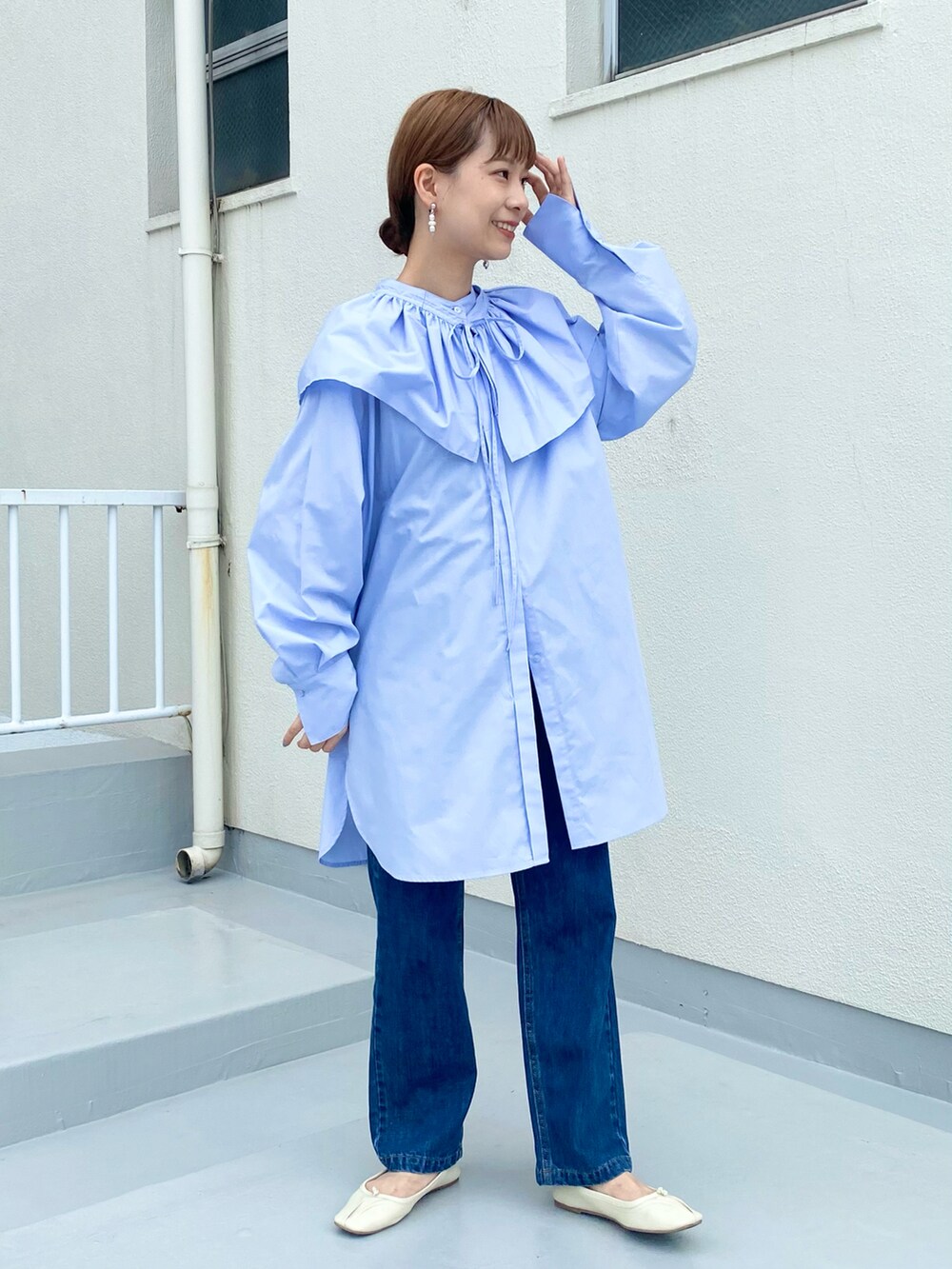 ブルー系のデニムパンツ、パープル系のワンピース、ホワイト系のバレエシューズを着用したレディースの秋コーディネートの3枚目の写真