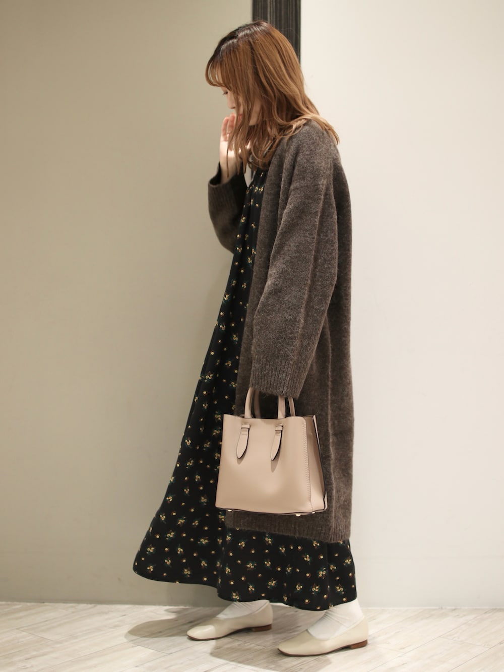 ブラウン系のトートバッグ、ブラック系のワンピース、ブラウン系のカーディガン/ボレロを着用したレディースの秋コーディネートの3枚目の写真