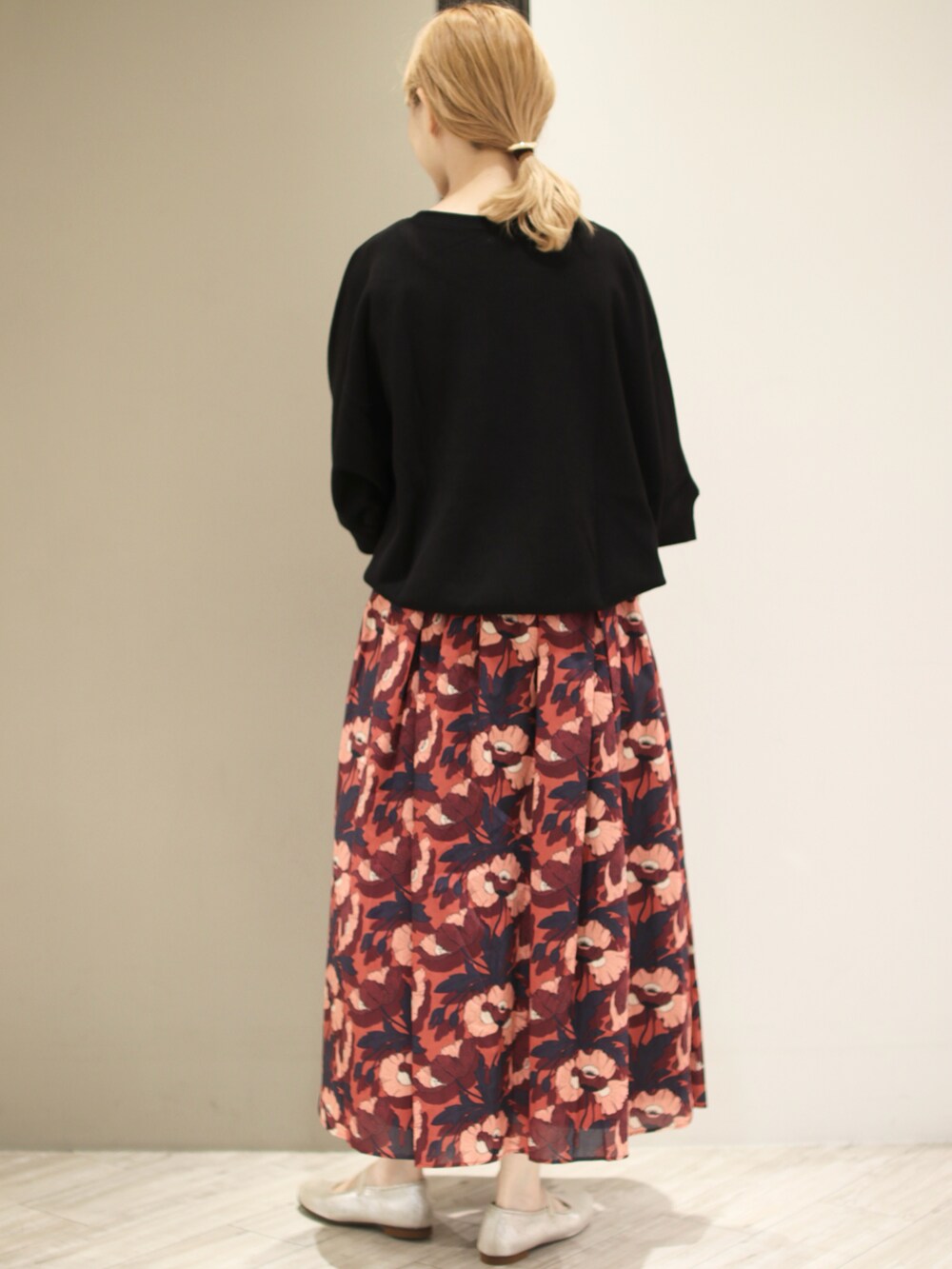 ブラック系のTシャツ/カットソー、ブラウン系のスカート、ベージュ系のトートバッグを着用したレディースの秋コーディネートの4枚目の写真