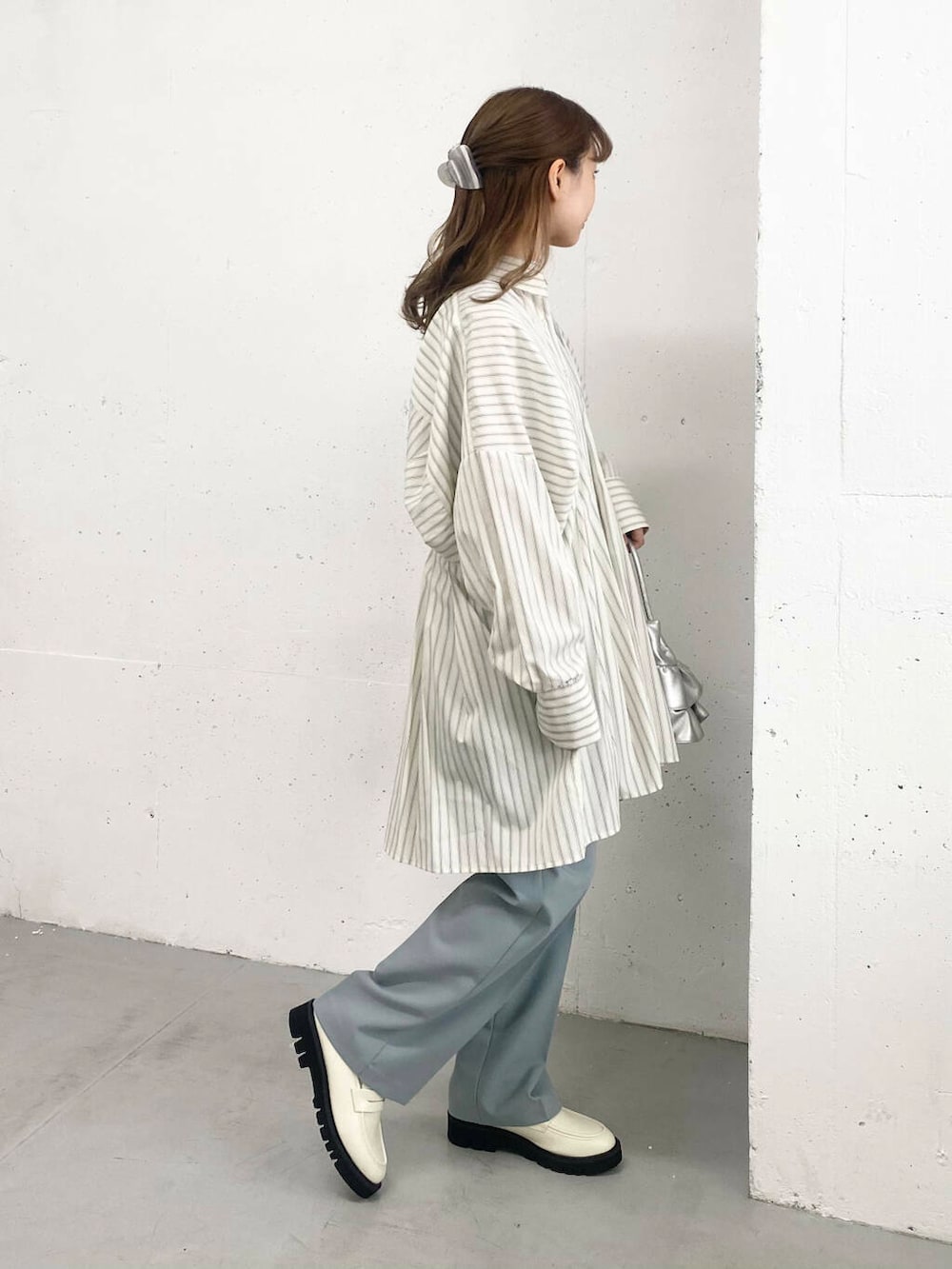 ブルー系のその他パンツ、ホワイト系のローファー、シルバー系のハンドバッグを着用したレディースの春コーディネートの6枚目の写真