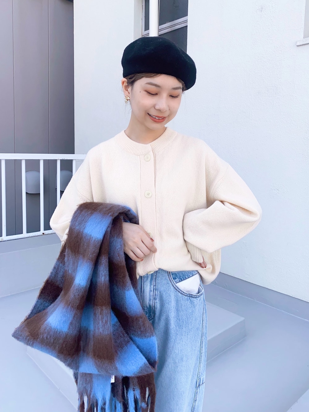 ブルー系のデニムパンツ、ブラック系のバレエシューズ、ホワイト系のカーディガン/ボレロを着用したレディースの冬コーディネートの4枚目の写真