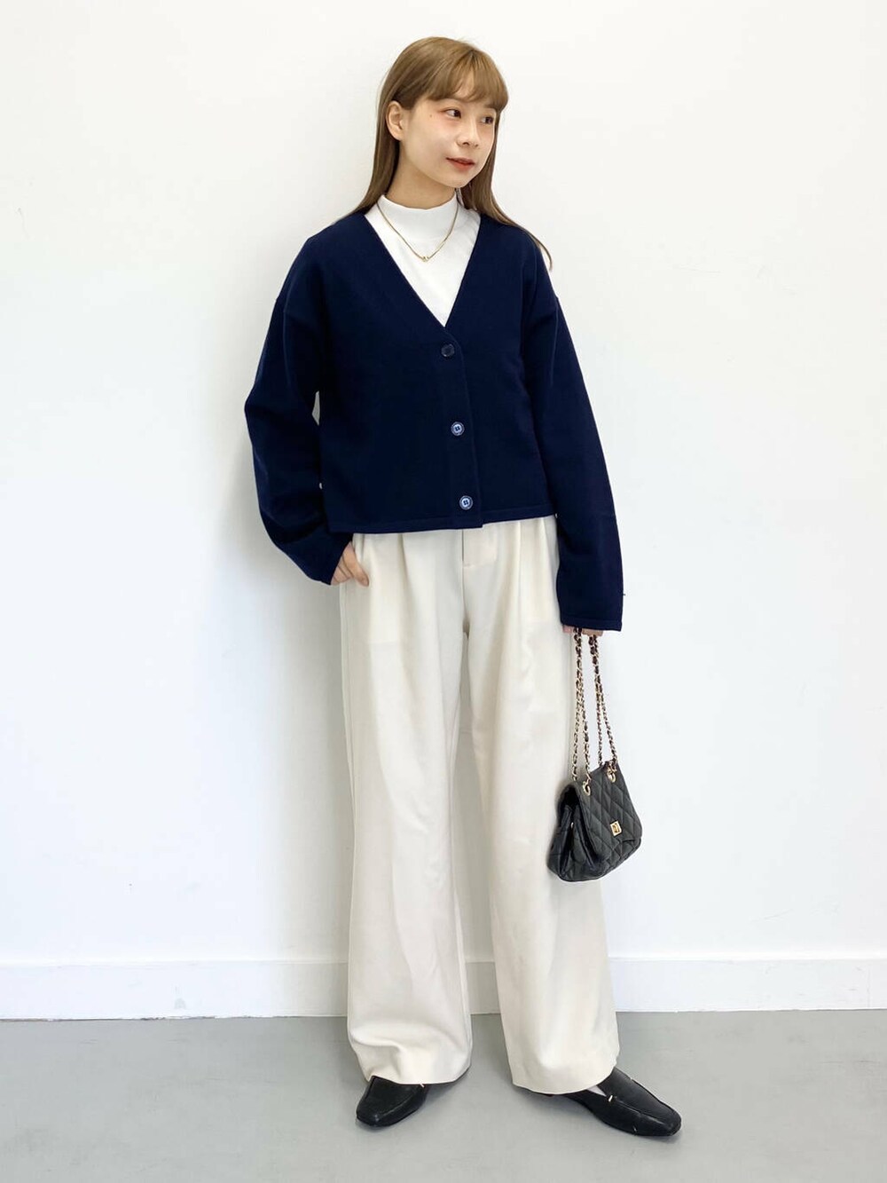 ブラック系のローファー、ブラック系のショルダーバッグ、ホワイト系のTシャツ/カットソーを着用したレディースの冬コーディネートの3枚目の写真