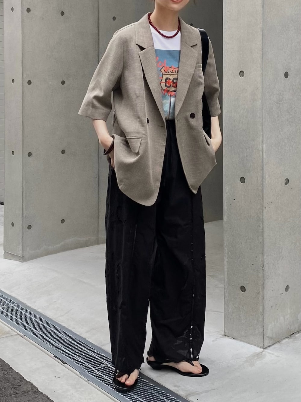 ホワイト系のTシャツ/カットソー、ベージュ系のその他アウター、ブラック系のその他パンツを着用したレディースの秋コーディネートの5枚目の写真