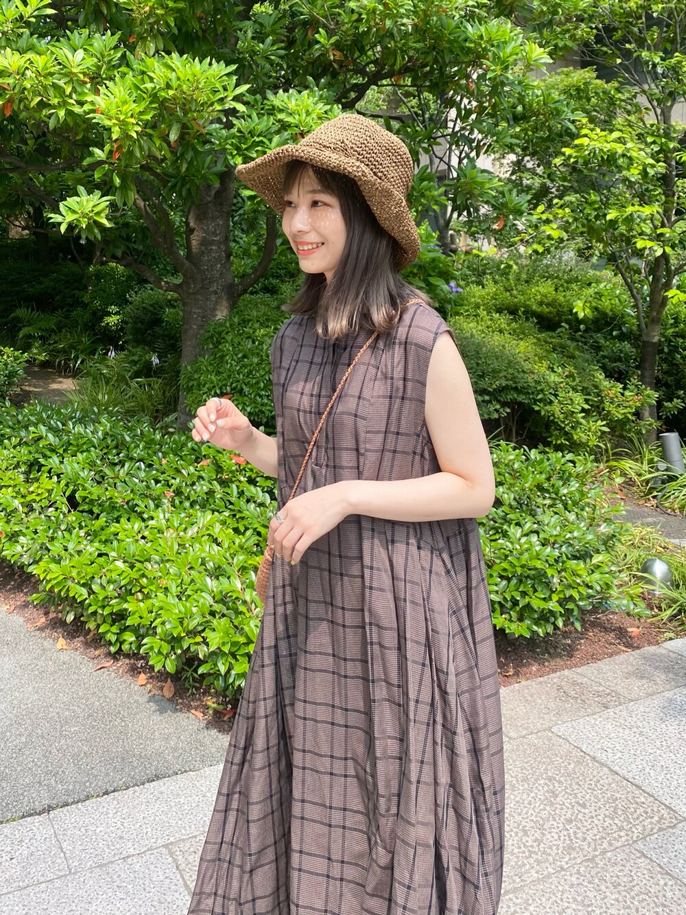 ベージュ系のかごバッグ、ブラウン系のワンピース、ベージュ系のサンダルを着用したレディースの夏コーディネートの4枚目の写真