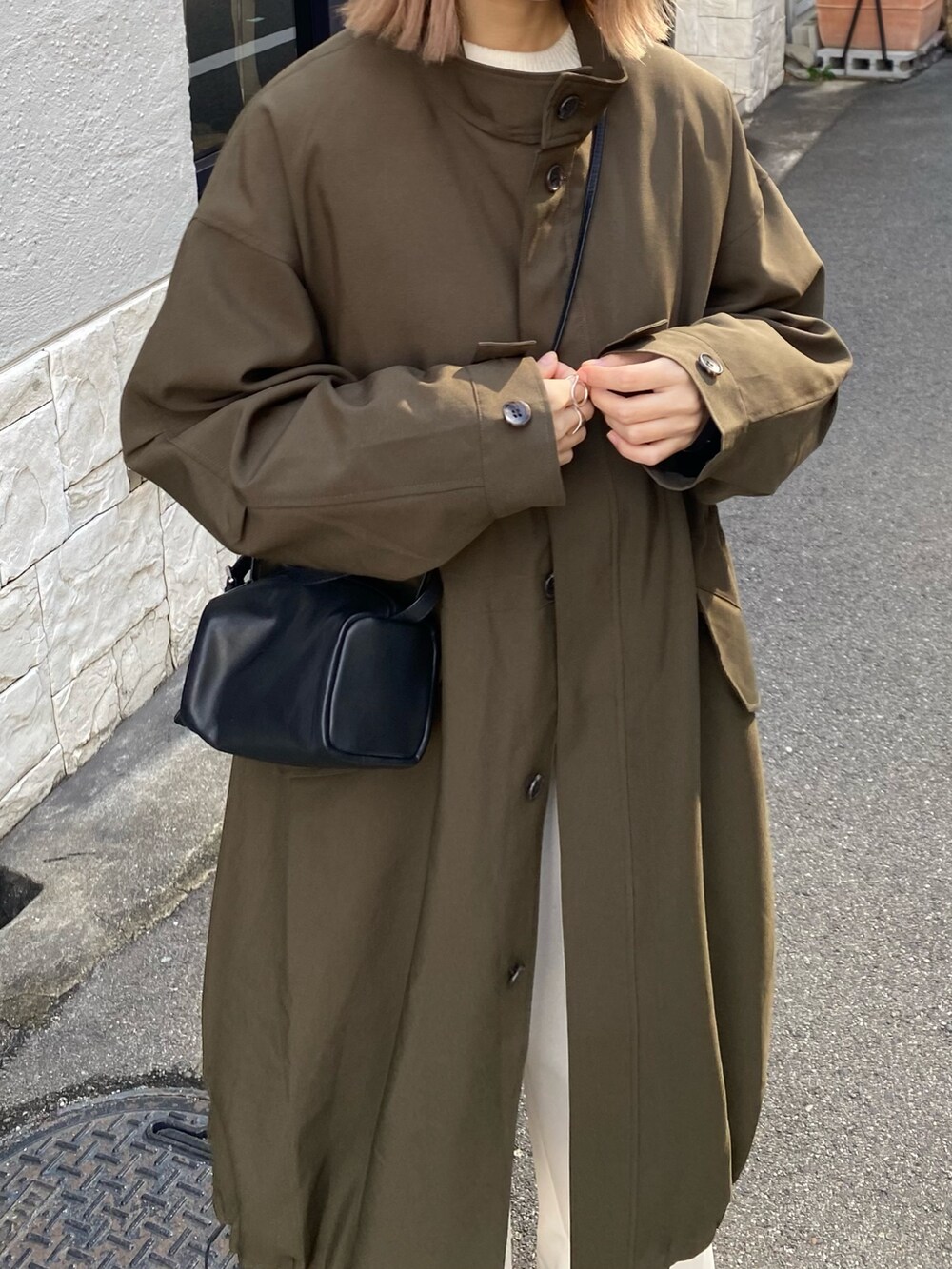 グリーン系のその他アウター、ホワイト系のその他パンツ、ブラック系のパンプスを着用したレディースの冬コーディネートの6枚目の写真