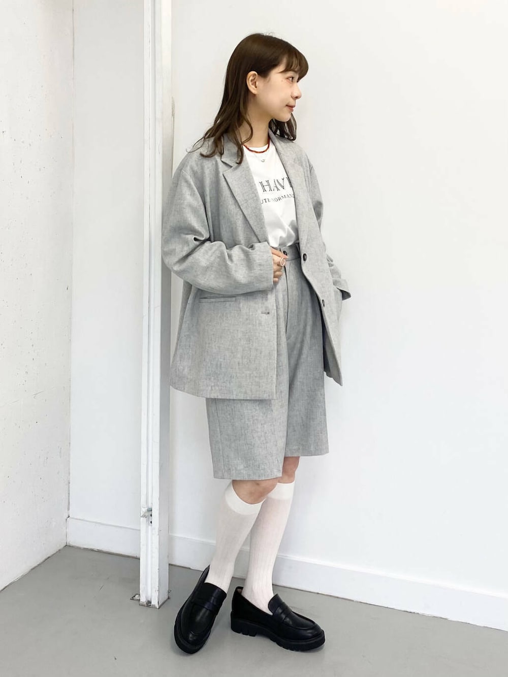 ブラック系のローファー、グレー系のその他パンツ、レッド系のネックレスを着用したレディースの春コーディネートの6枚目の写真