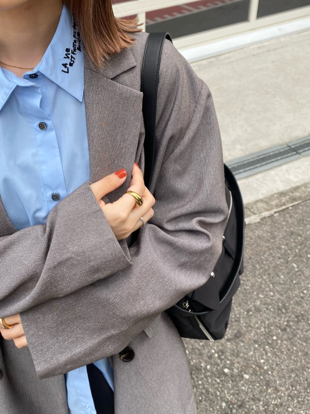 ブラック系のショルダーバッグ、グレー系のその他アウター、ブルー系のシャツ/ブラウスを着用したレディースの秋コーディネートの5枚目の写真