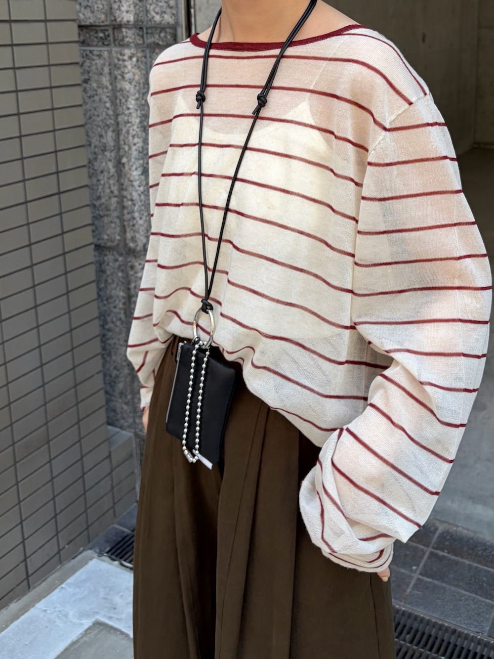ブラウン系のその他パンツ、ベージュ系のニット/セーター、ブラック系のローファーを着用したレディースの秋コーディネートの5枚目の写真