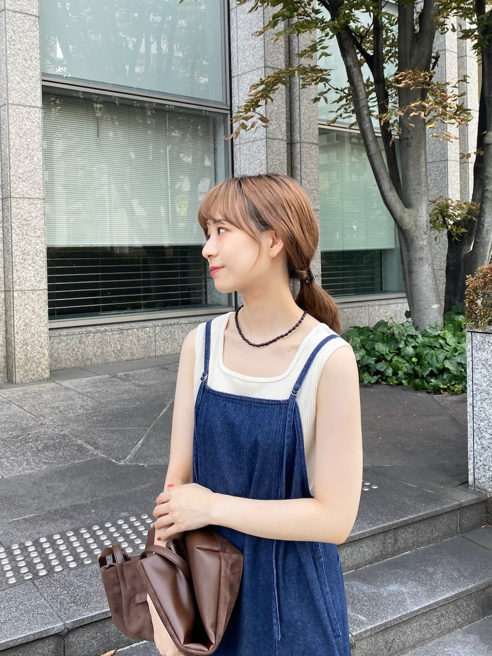 ブルー系のワンピース、ブラウン系のトートバッグ、ホワイト系のタンクトップを着用したレディースの秋コーディネートの3枚目の写真