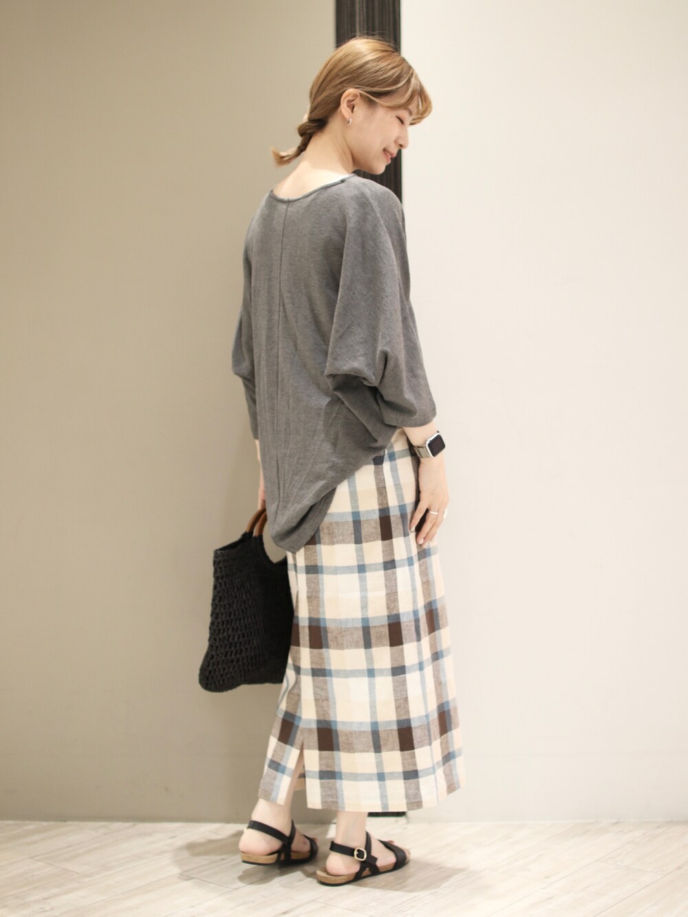 グレー系のTシャツ/カットソー、ブルー系のスカート、ブラック系のトートバッグを着用したレディースの夏コーディネートの2枚目の写真