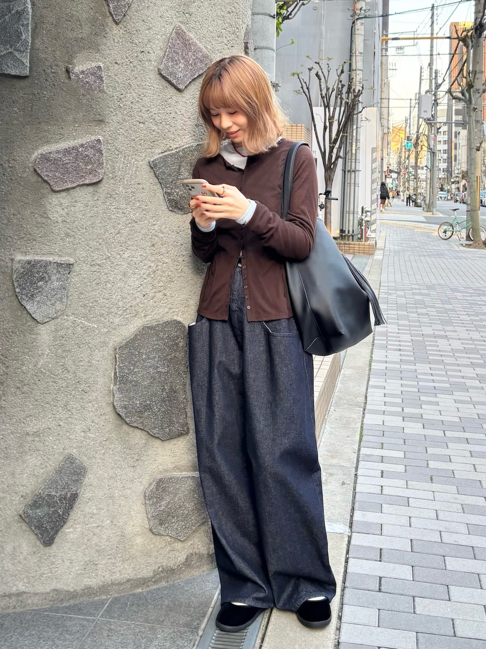 ブラック系のその他シューズ、ブラウン系のTシャツ/カットソー、ブラック系のトートバッグを着用したレディースの秋コーディネートの3枚目の写真