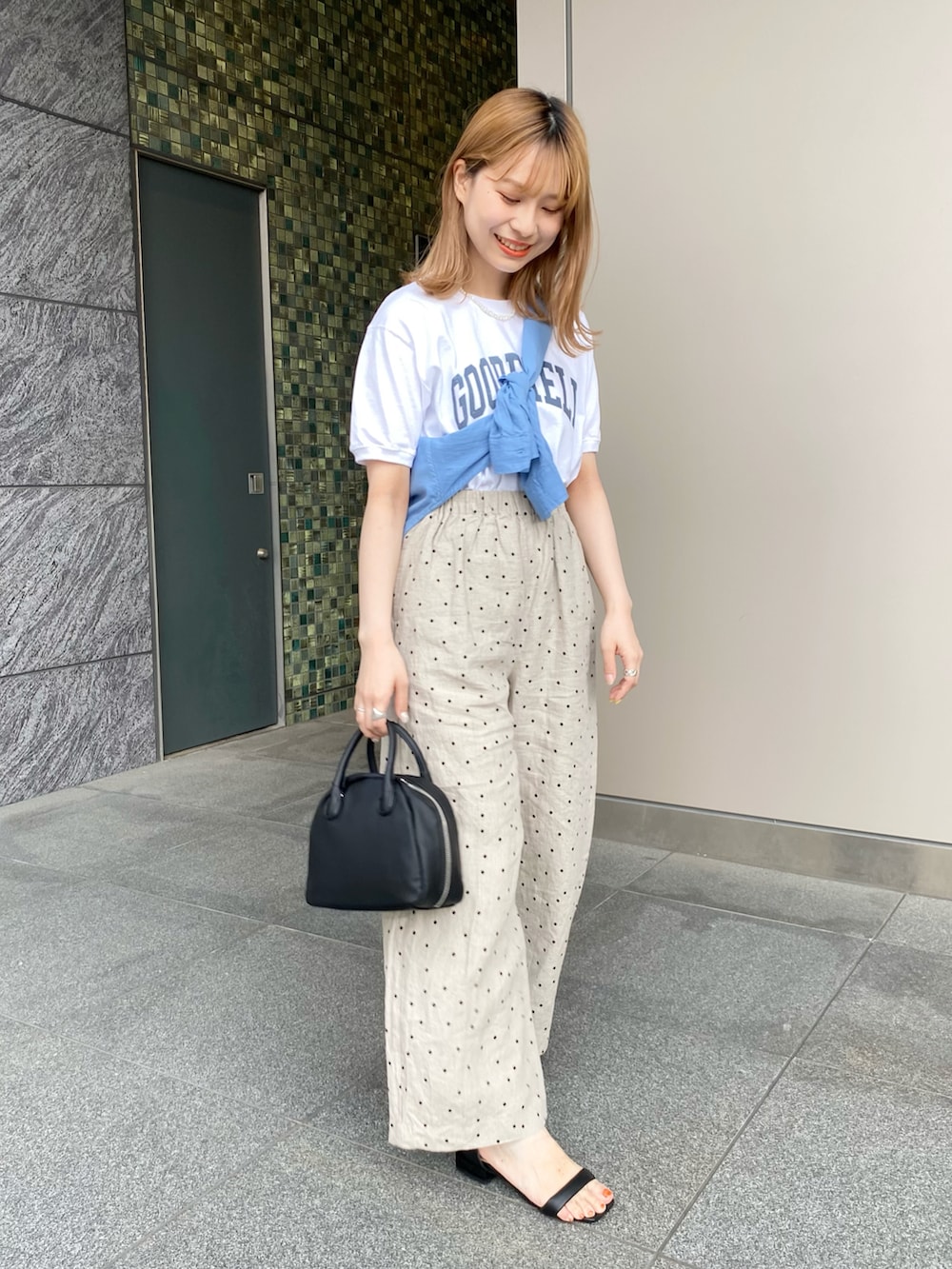 ブラック系のサンダル、ブラック系のボストンバッグ、ベージュ系のその他パンツを着用したレディースの夏コーディネートの2枚目の写真