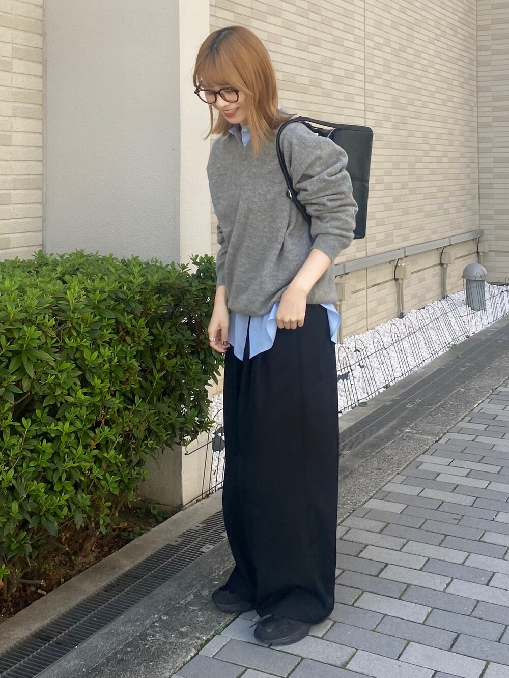 ブルー系のシャツ/ブラウス、ブラック系のボストンバッグ、グレー系のニット/セーターを着用したレディースの秋コーディネートの2枚目の写真