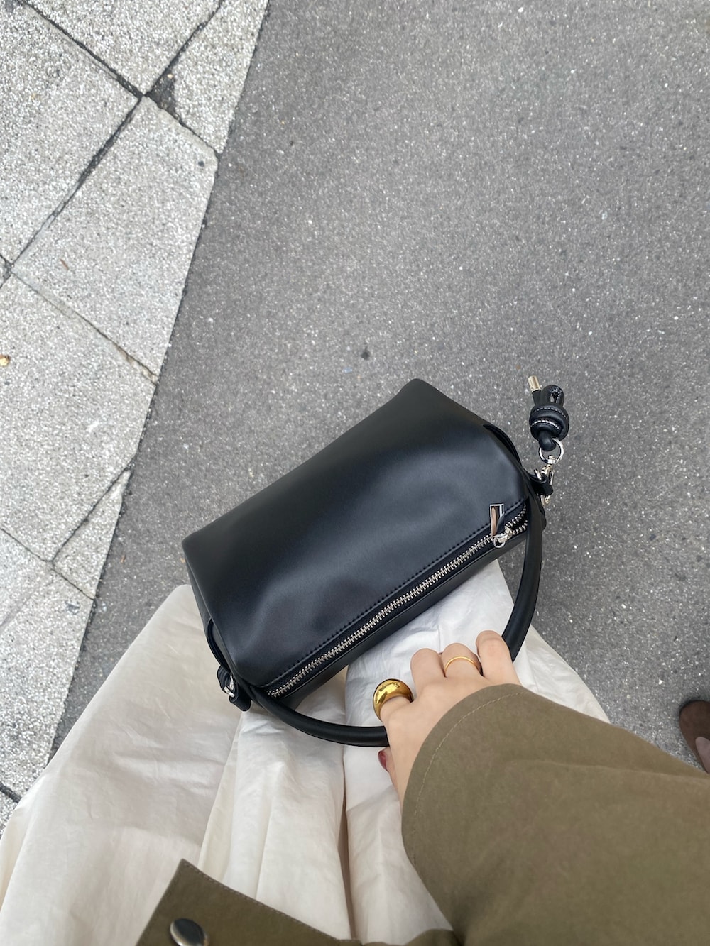 グリーン系のブルゾン、ホワイト系のスカート、ブラウン系のメガネを着用したレディースの春コーディネートの7枚目の写真